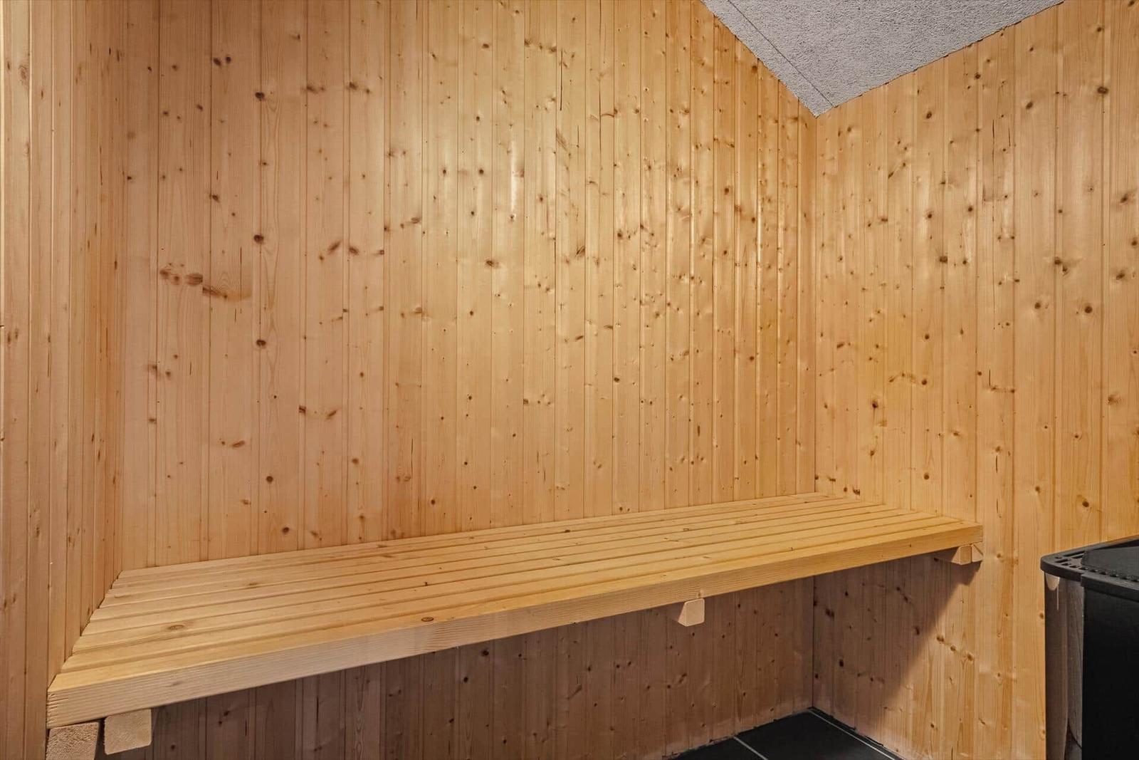 Holzsauna mit Bank und Ofen im Raum