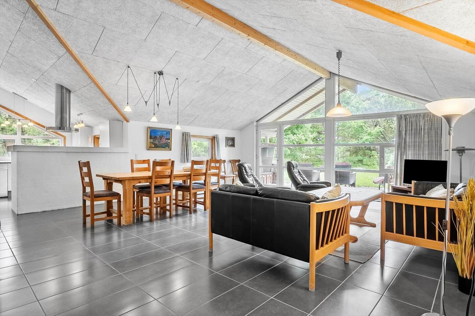 Großer Wohn- und Essbereich mit Holzmöbeln und großem Fensterblick.