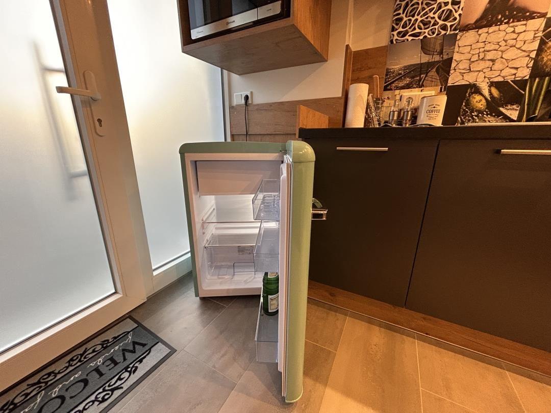 Küche mit kleinem Kühlschrank und Arbeitsfläche