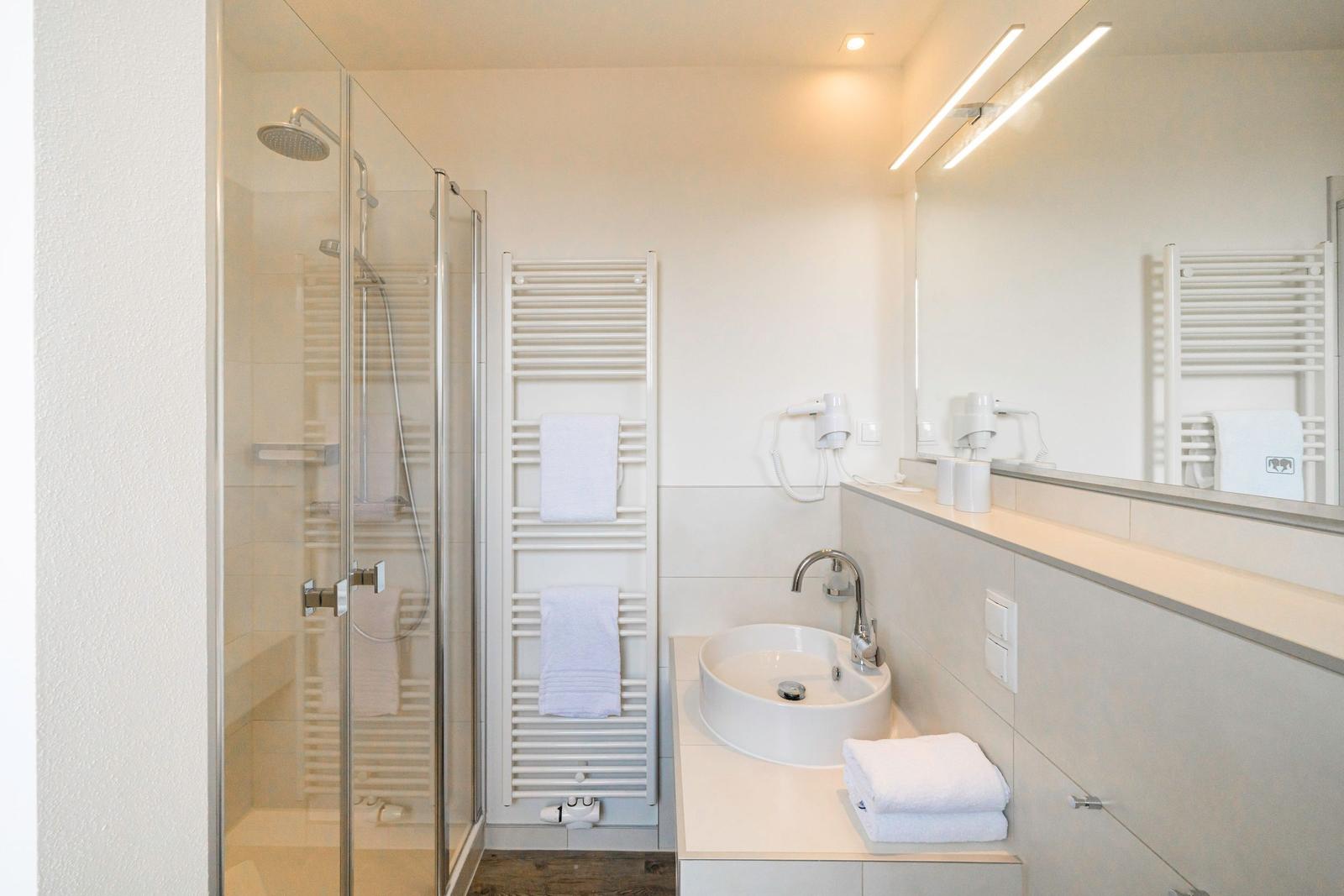 Bad mit Dusche, Waschbecken und Handtuchheizung