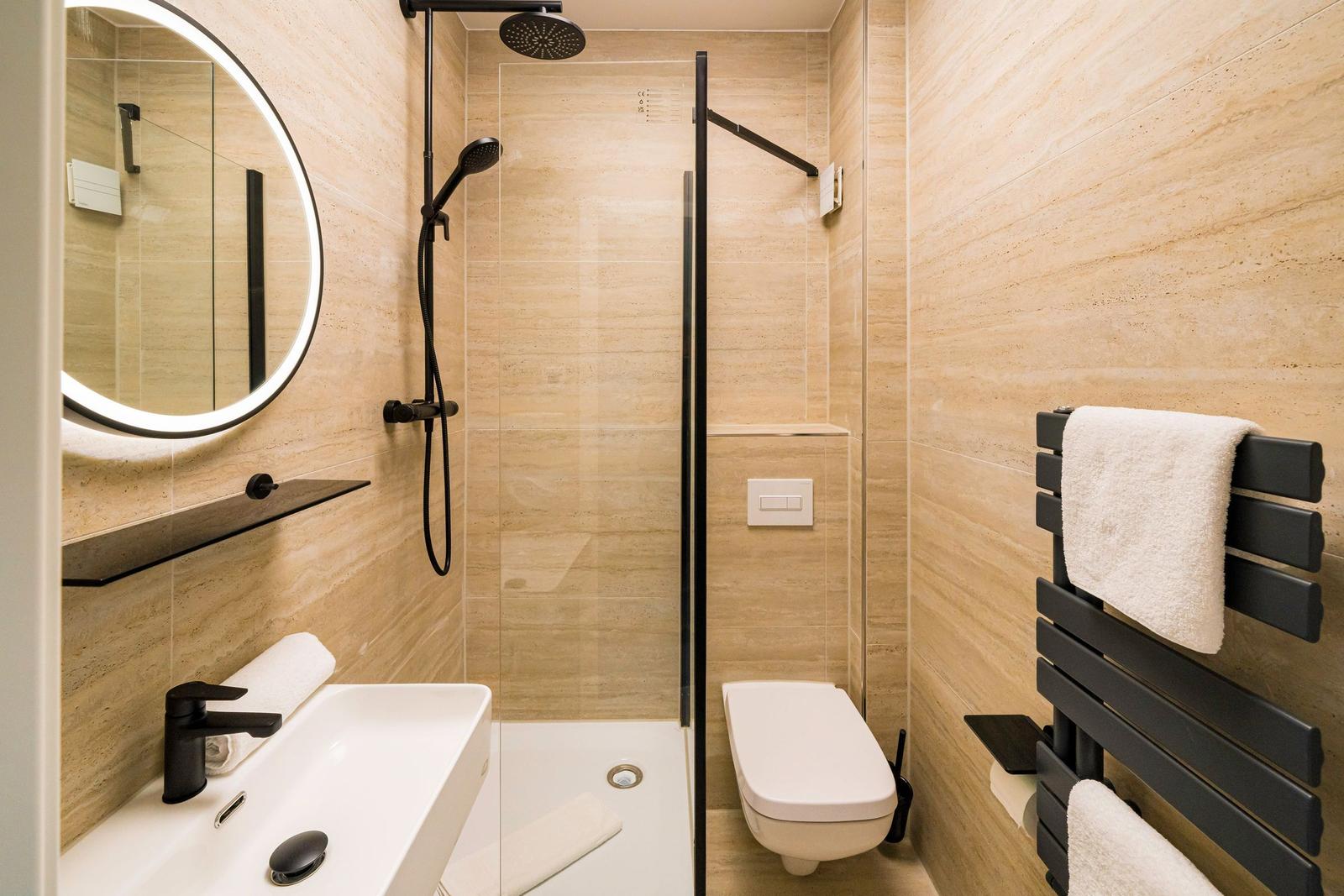 Badezimmer mit Dusche, Waschbecken und Toilette.