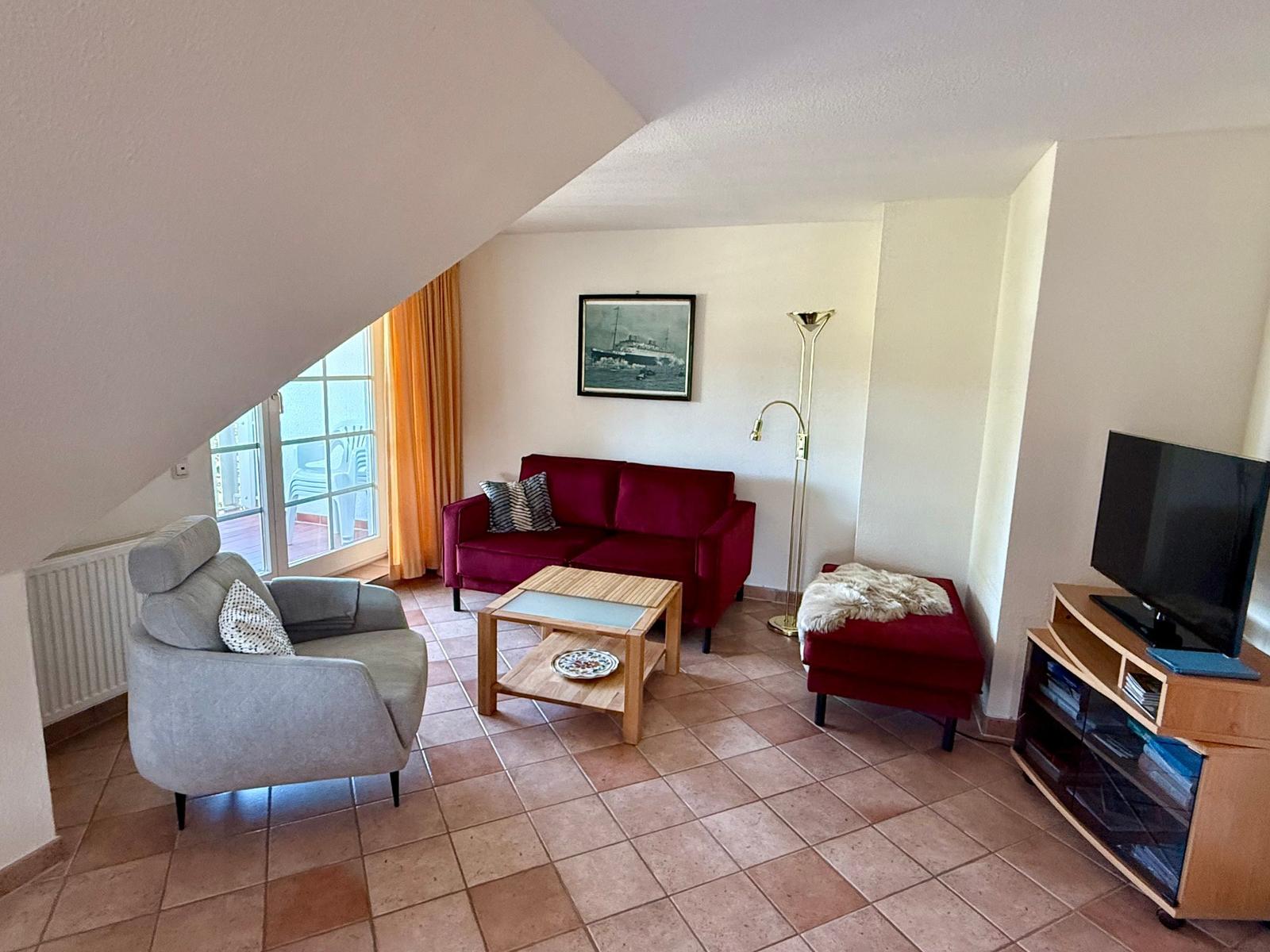 Wohnbereich mit Sofa, Sessel und TV