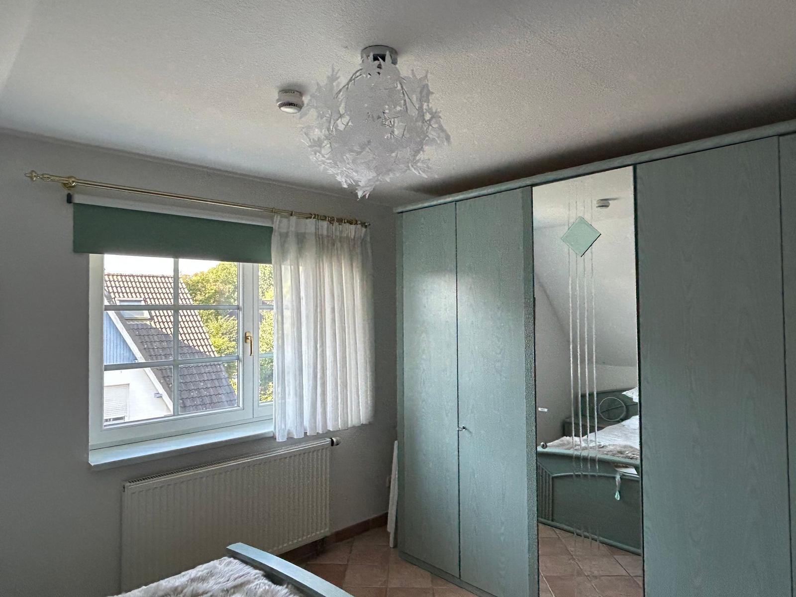 Schlafzimmer mit Doppelbett und Kleiderschrank