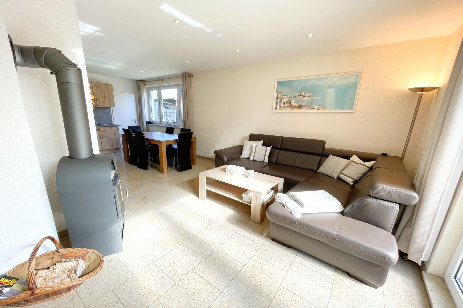 Wohn- und Essbereich mit Sofa, Kamin und Küchenbereich.