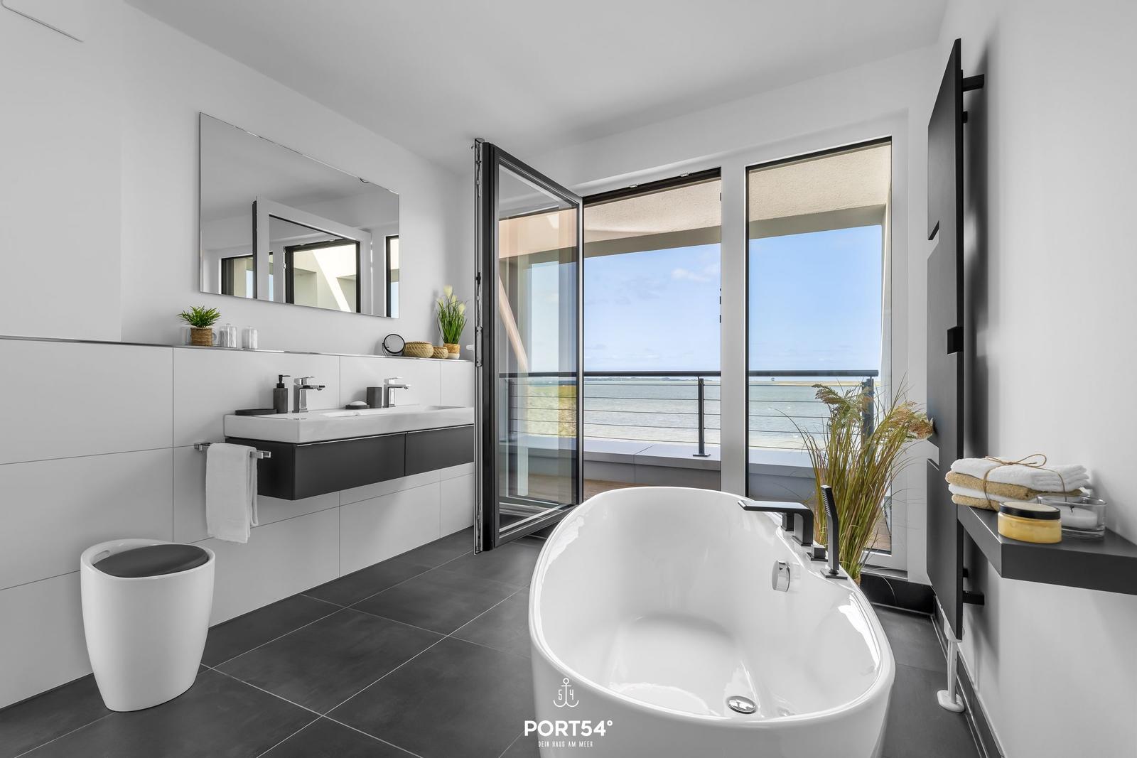 Bad mit Badewanne und Meerblick über Balkon