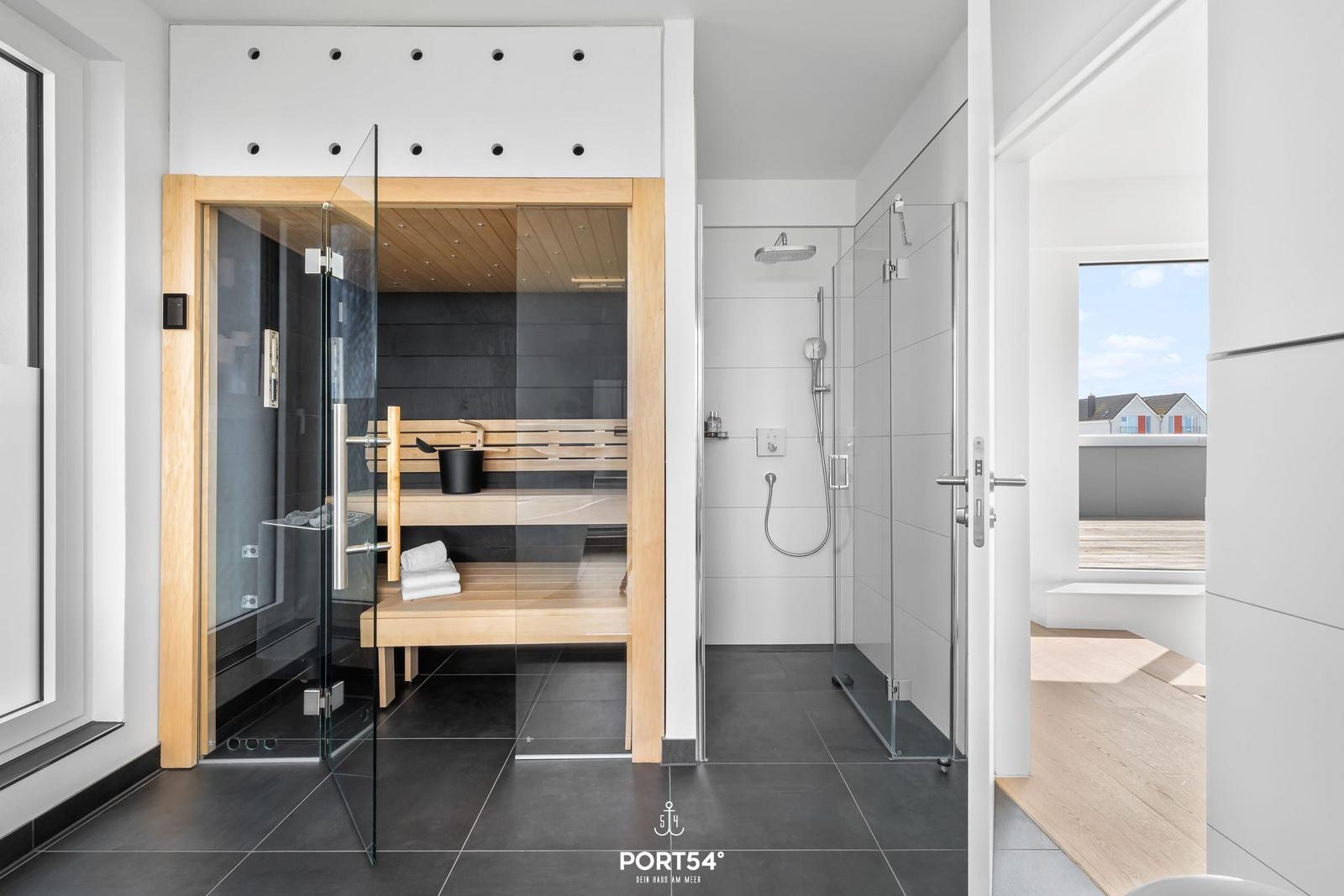 Dusche und Sauna mit Glaswand und Holzbank im modernen Badezimmer.