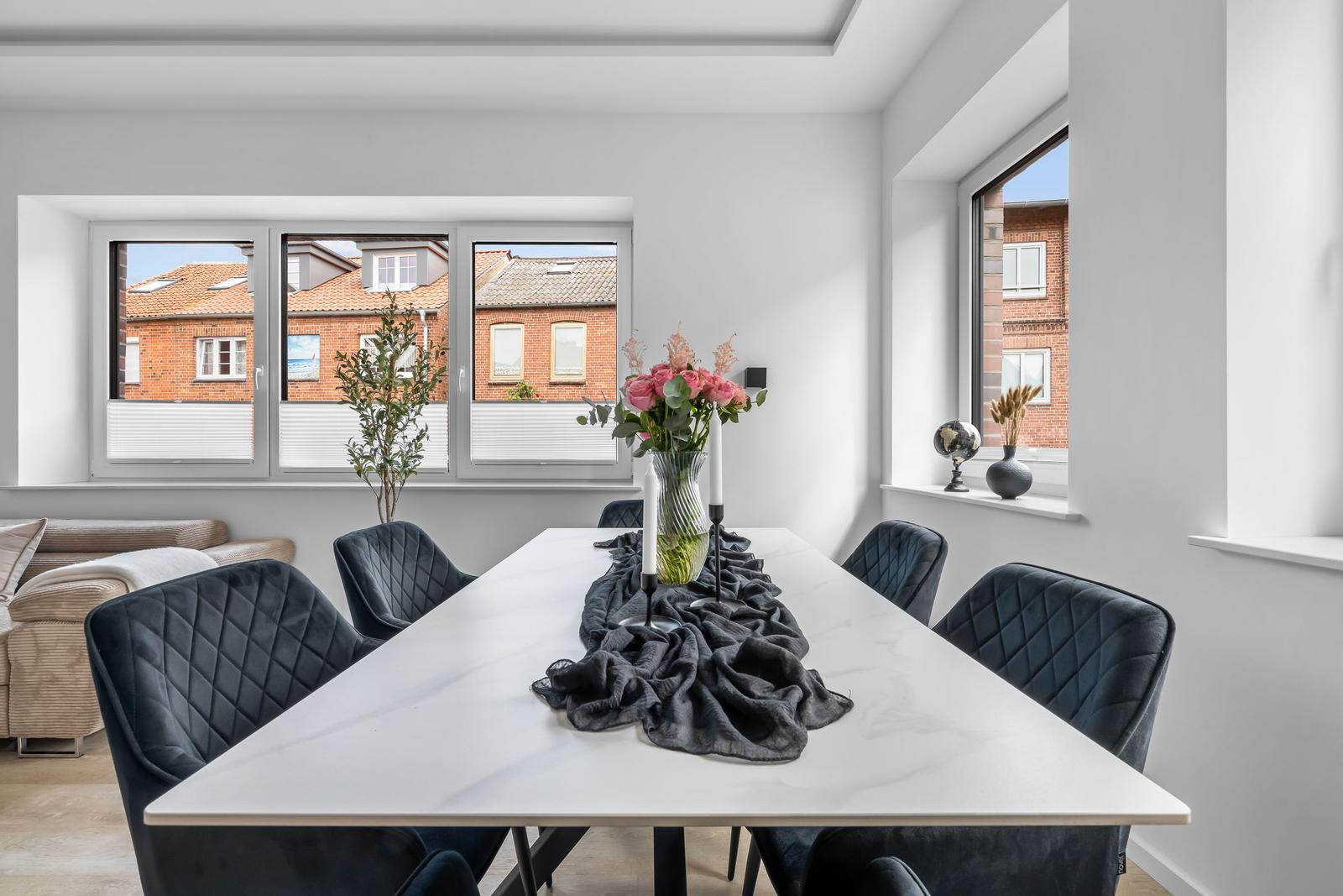 Esszimmer mit Tisch, Stühlen und Blick auf Gebäude