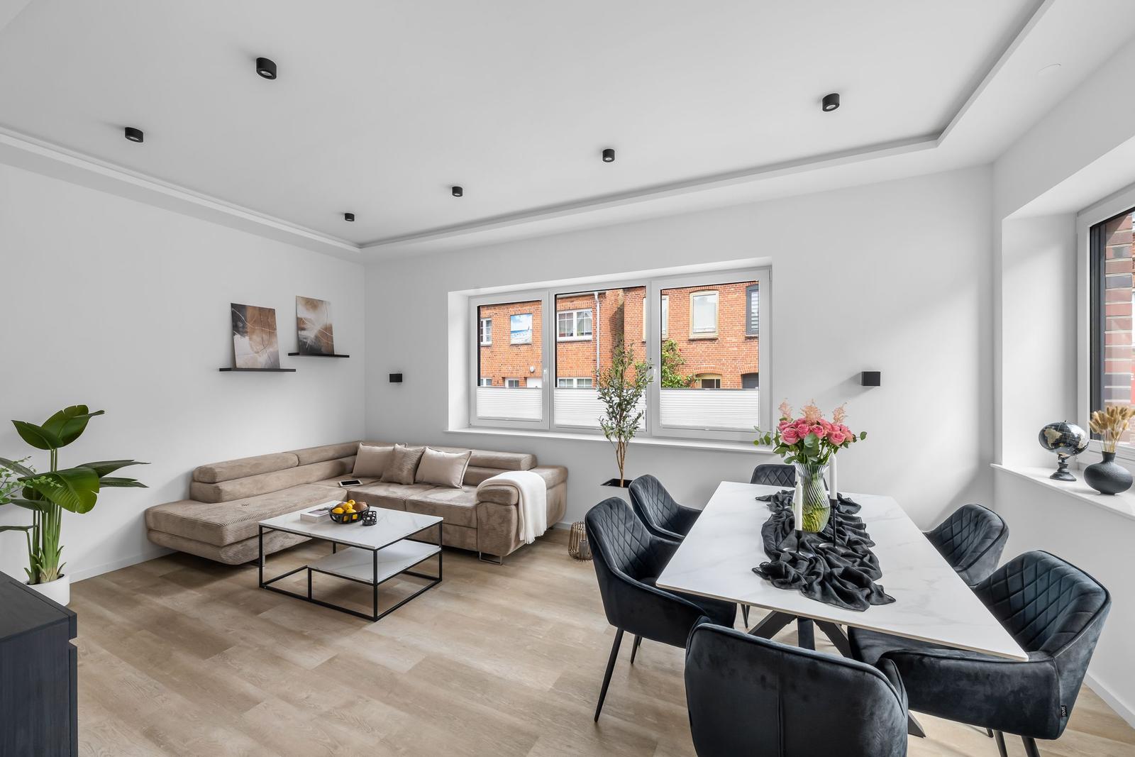 Wohn- und Essbereich mit Sofa, Esstisch und Fenster.