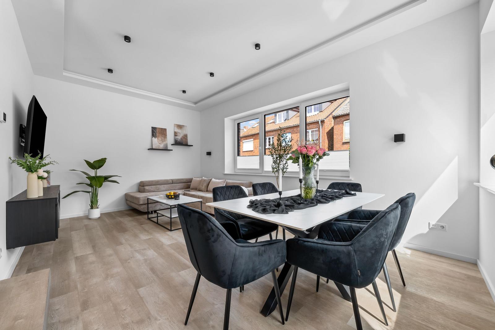 Esszimmer mit Tisch und Stühlen, Wohnbereich mit Sofa und Fernseher.