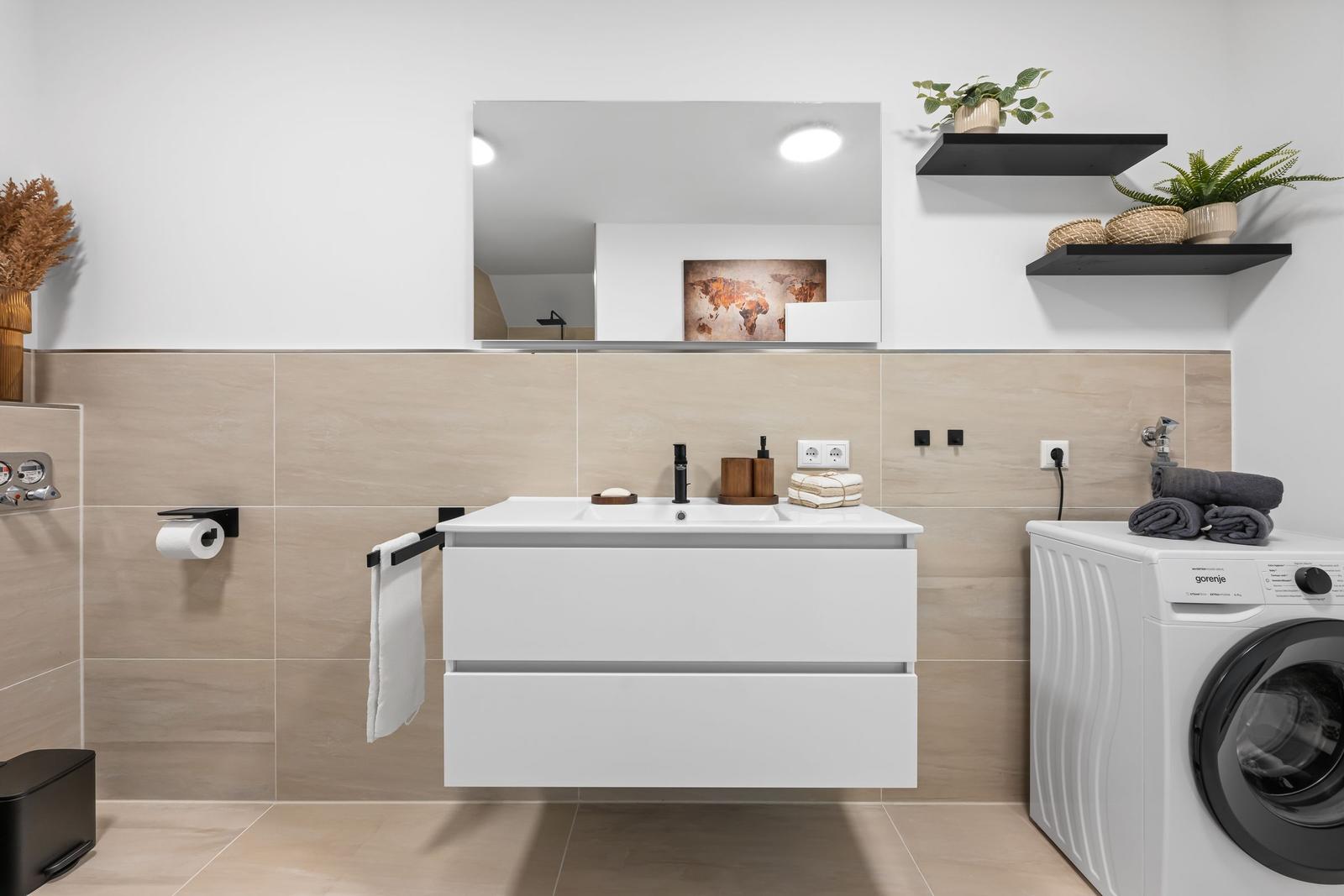 Badezimmer mit Waschmaschine und Spiegelschrank