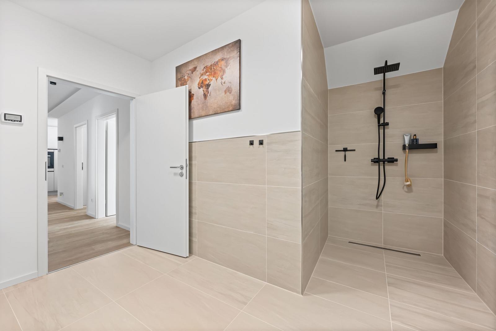 Dusche mit Duschbrause und Regendusche, Wandbild und Tür zum Flur.