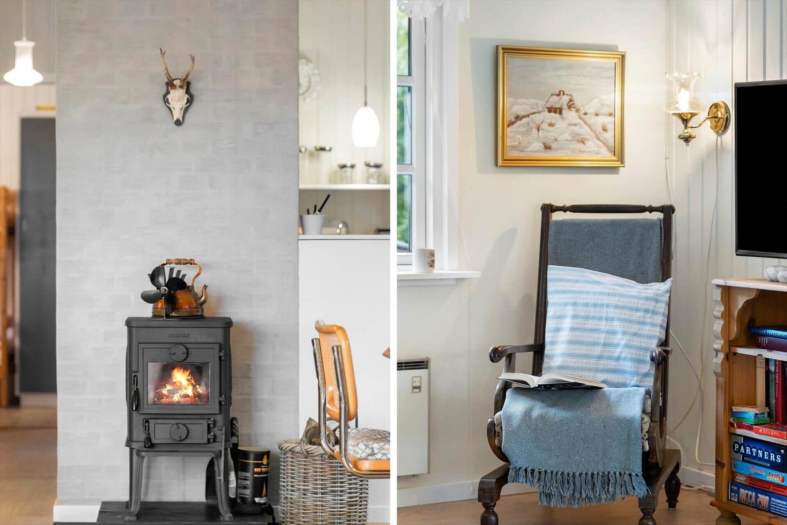 Kamin mit Teekanne und Hirschgeweih an der Wand. Sessel mit Decke und Buch.