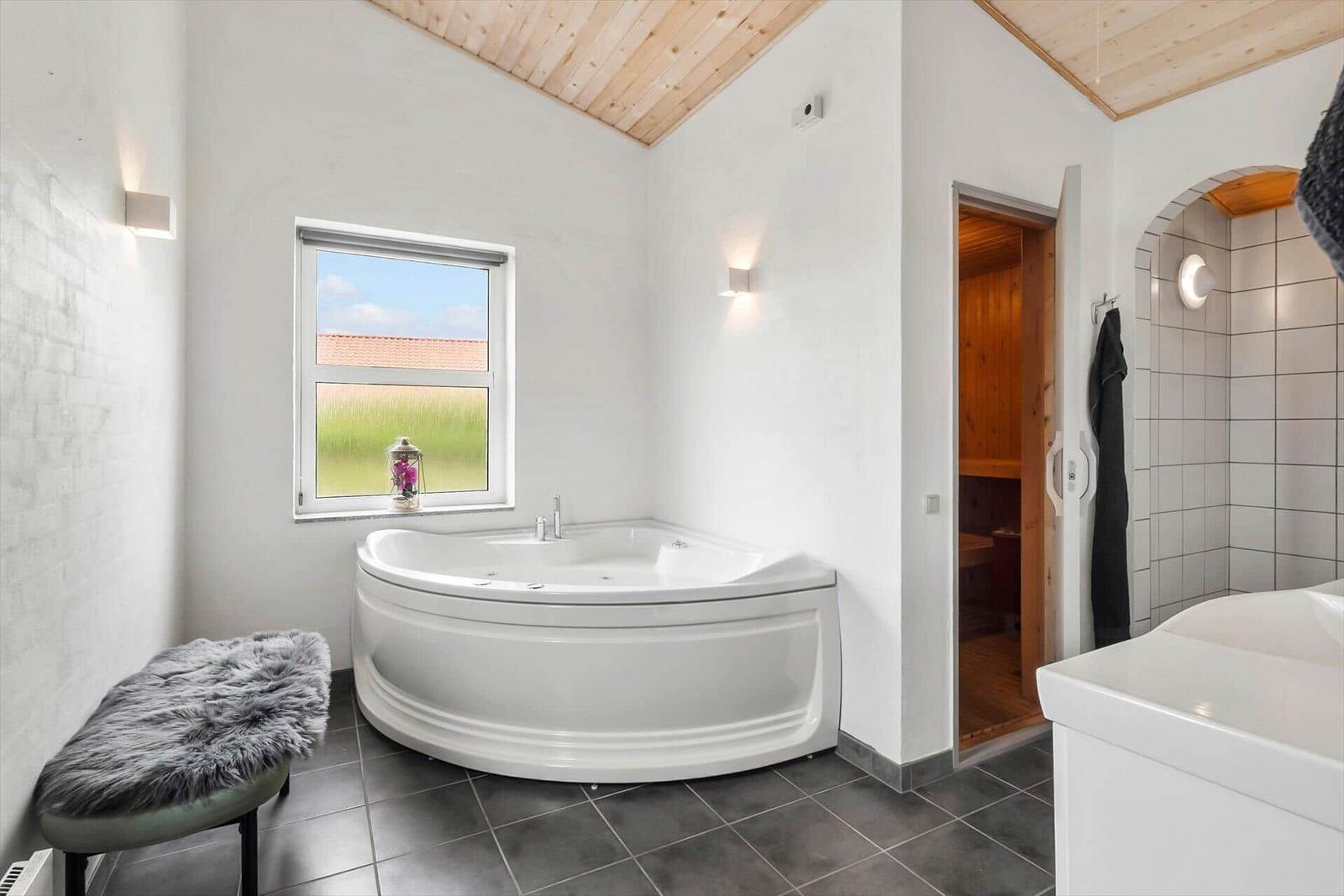 Bad mit Whirlpool, Sauna und Fenster mit Blick