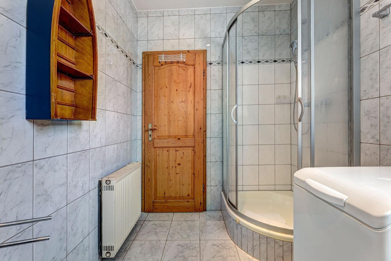 Bathroom with shower, bathtub, and wooden door