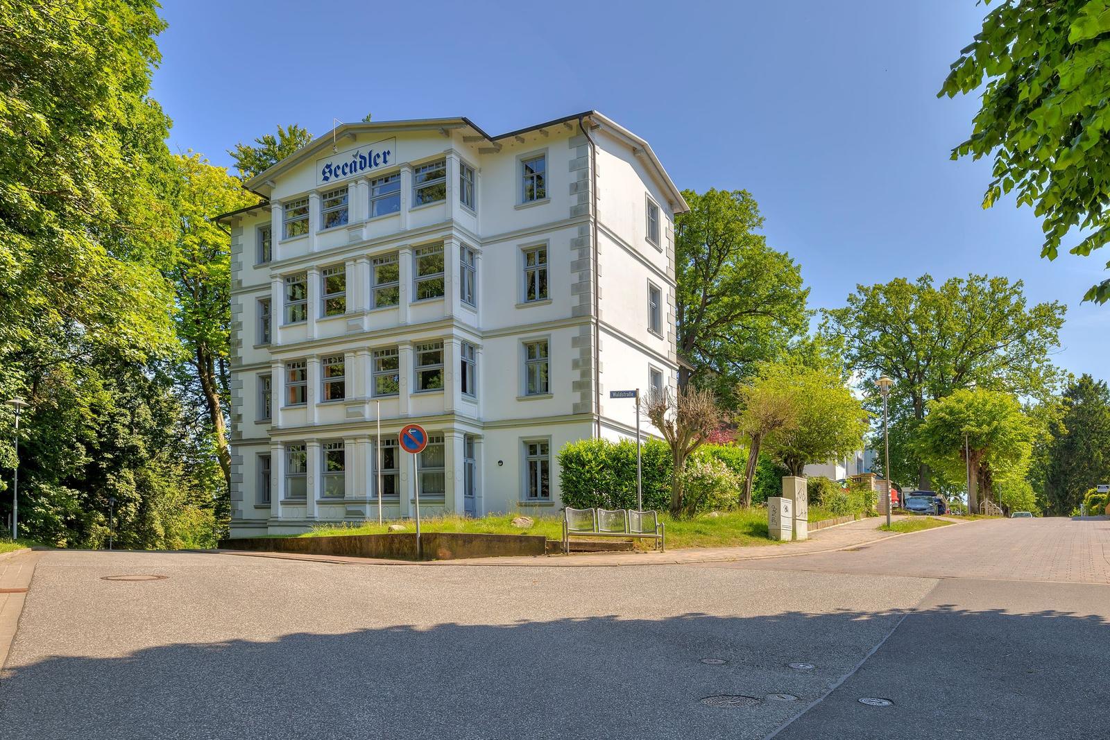 White villa with multiple windows and green surroundings
