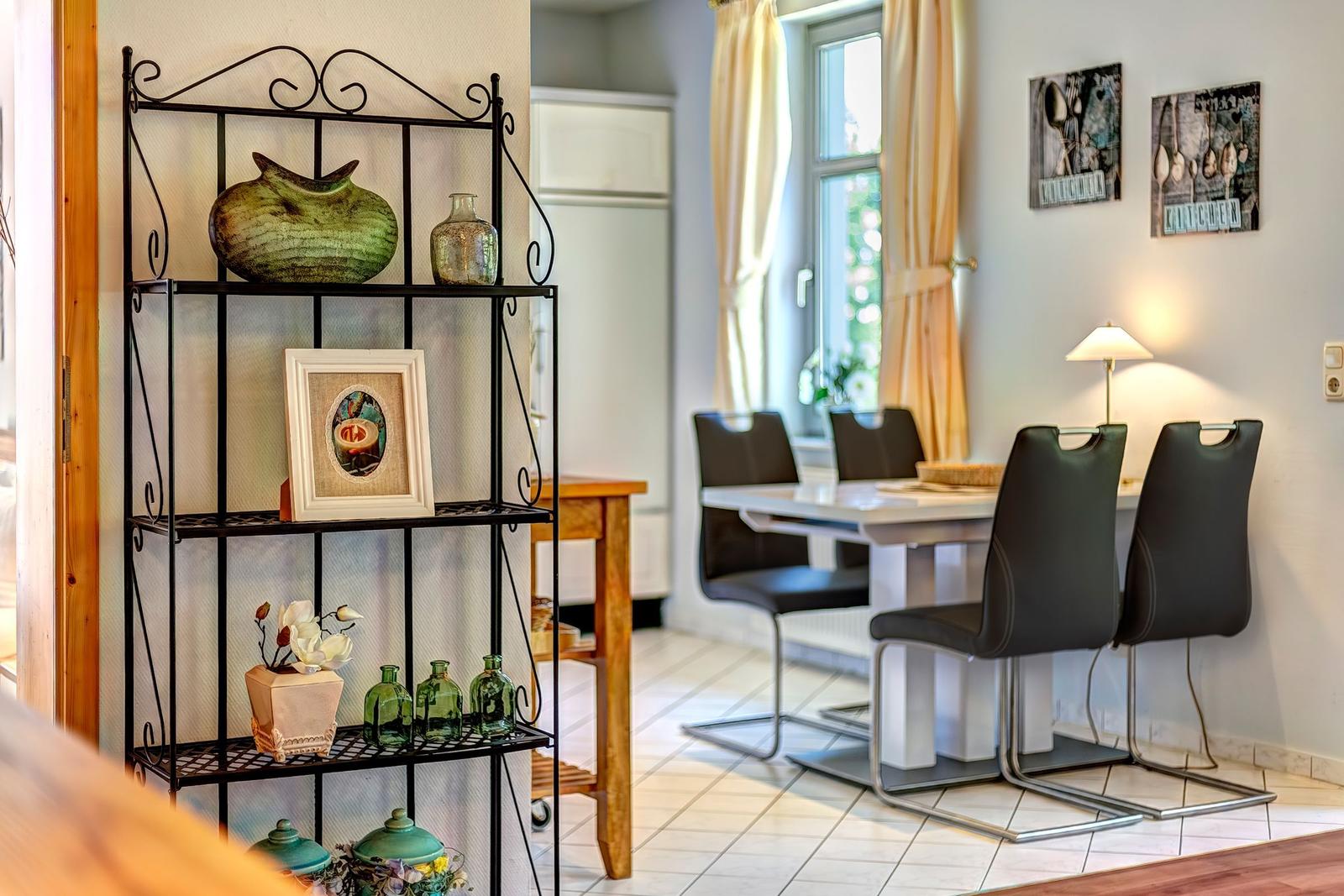 Dining room with table, chairs, and decorative shelves on the wall.