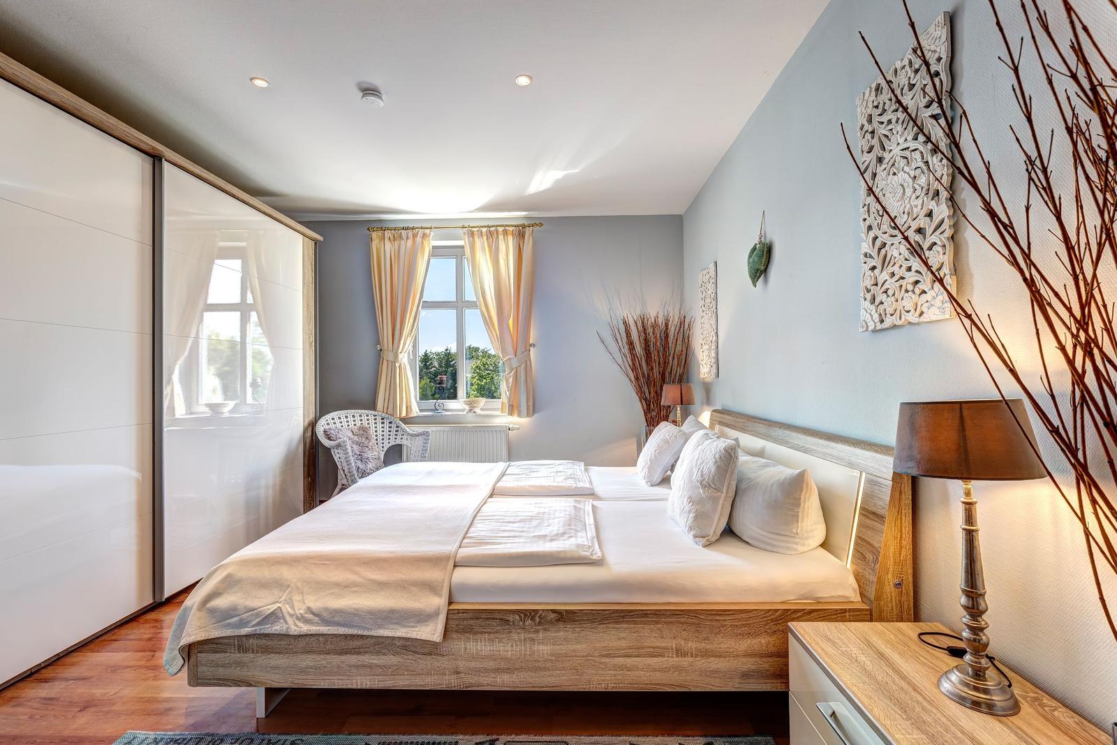 Bedroom with double bed, window, and wardrobe.