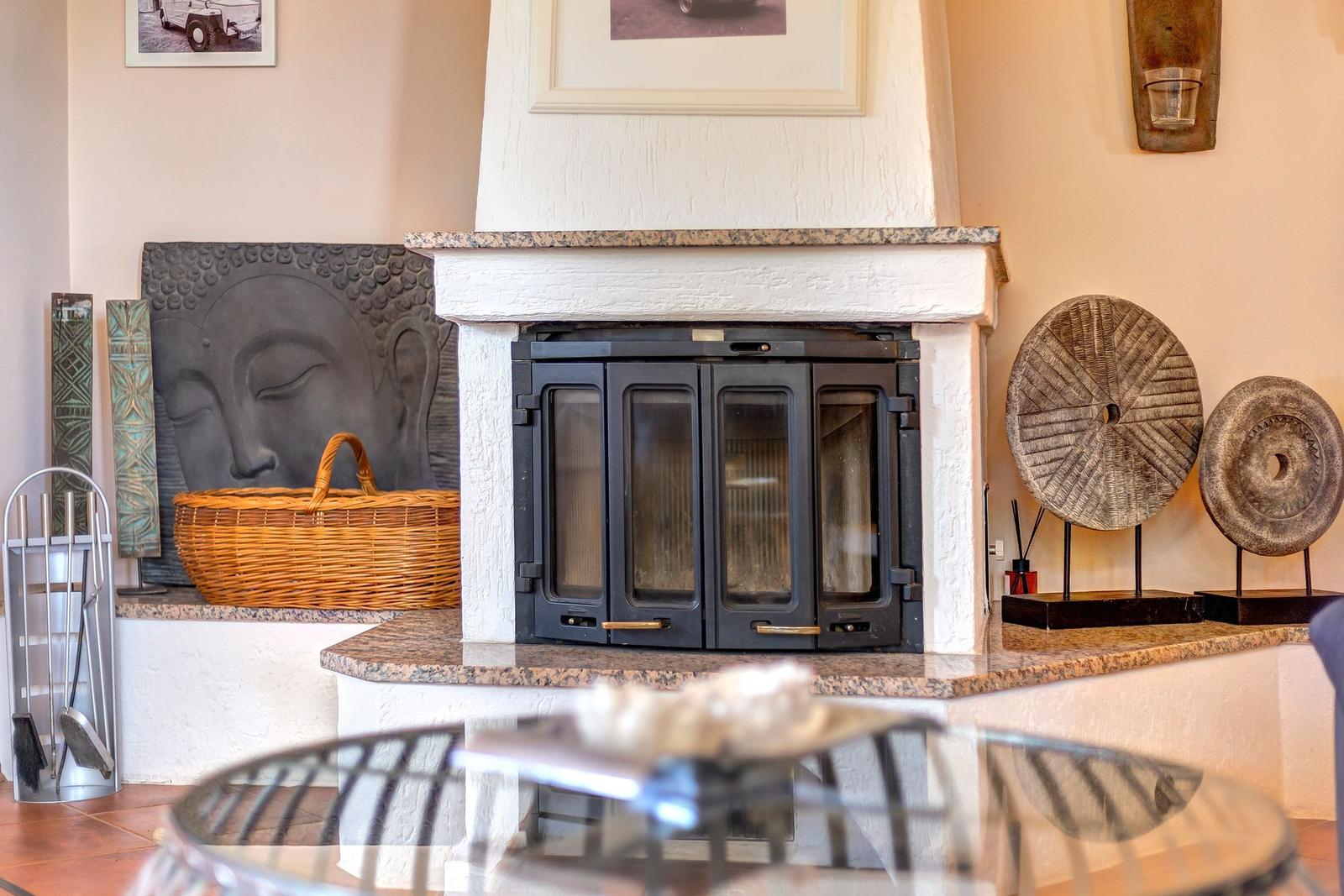 Kamin mit Steinsockel, dekorative Wandobjekte und Korb auf Sockel