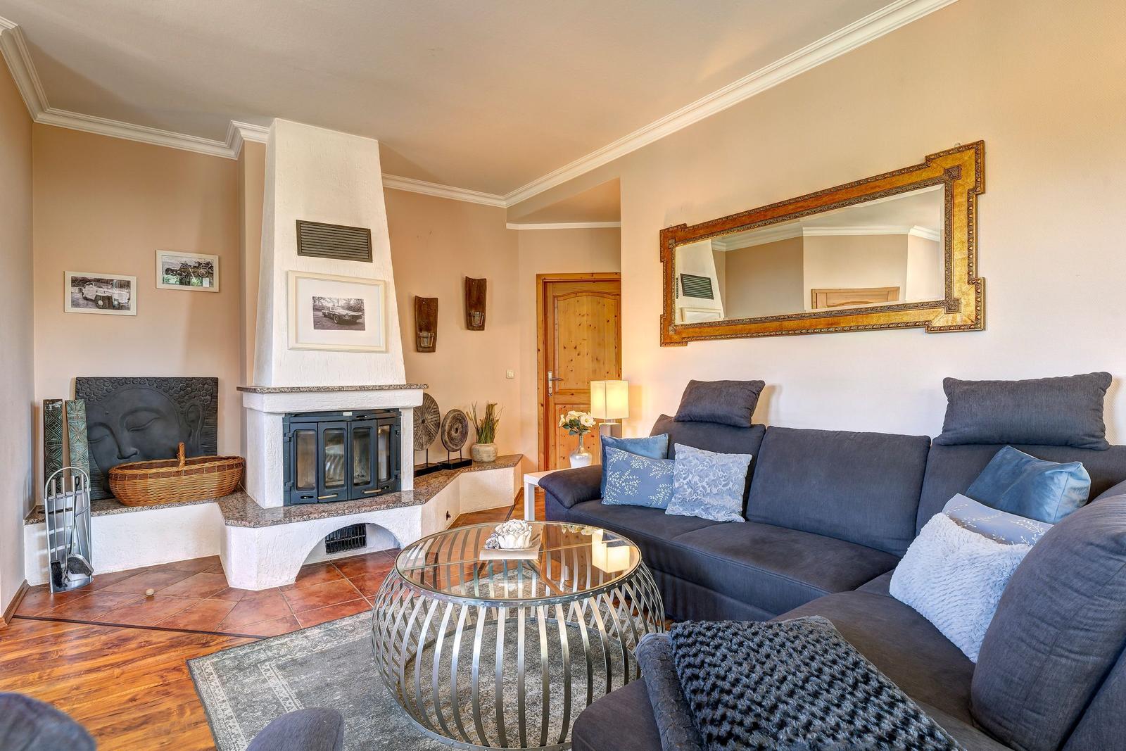 Wohnzimmer mit Sofa, Kamin und runden Tisch