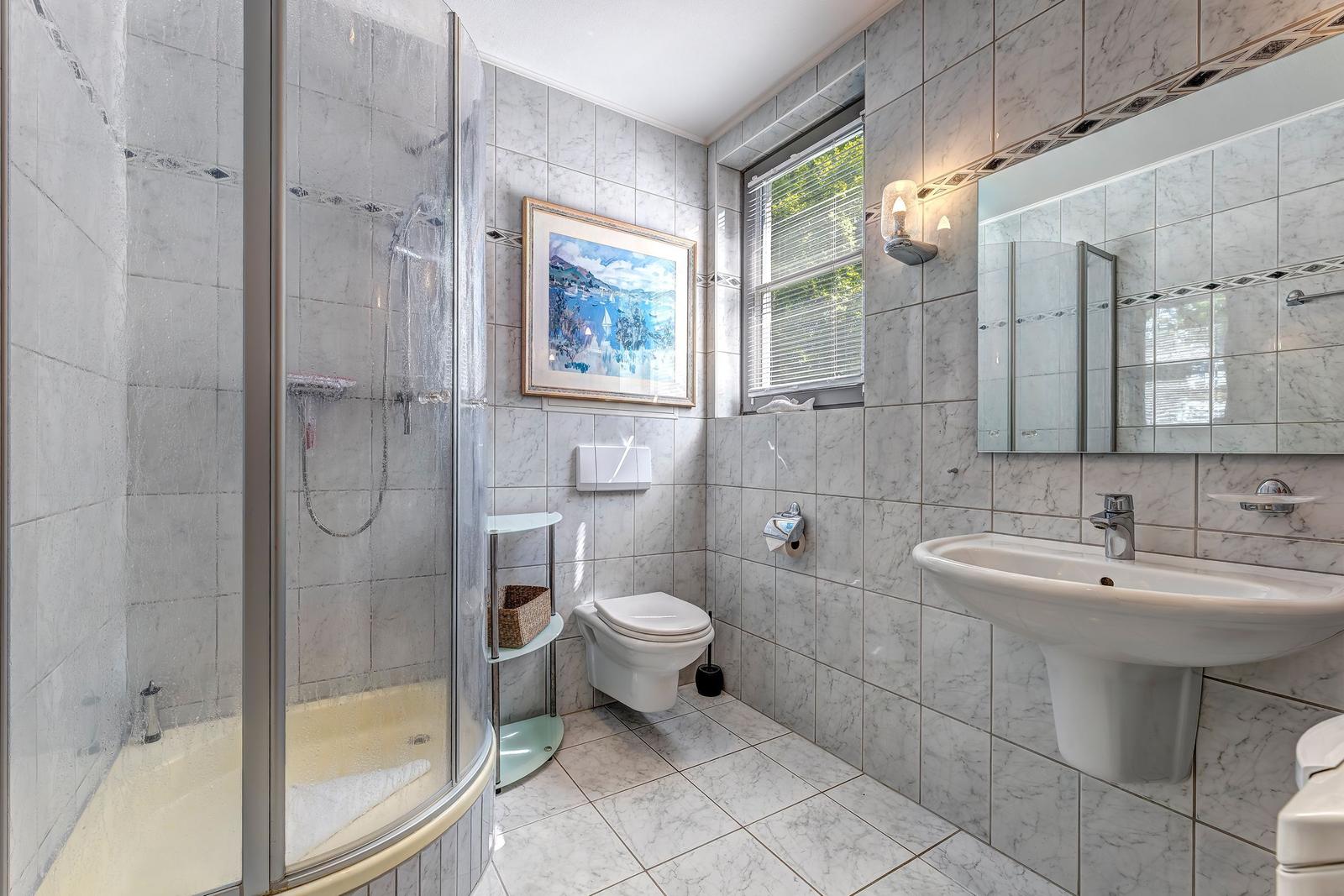 Badezimmer mit Dusche und Waschbecken