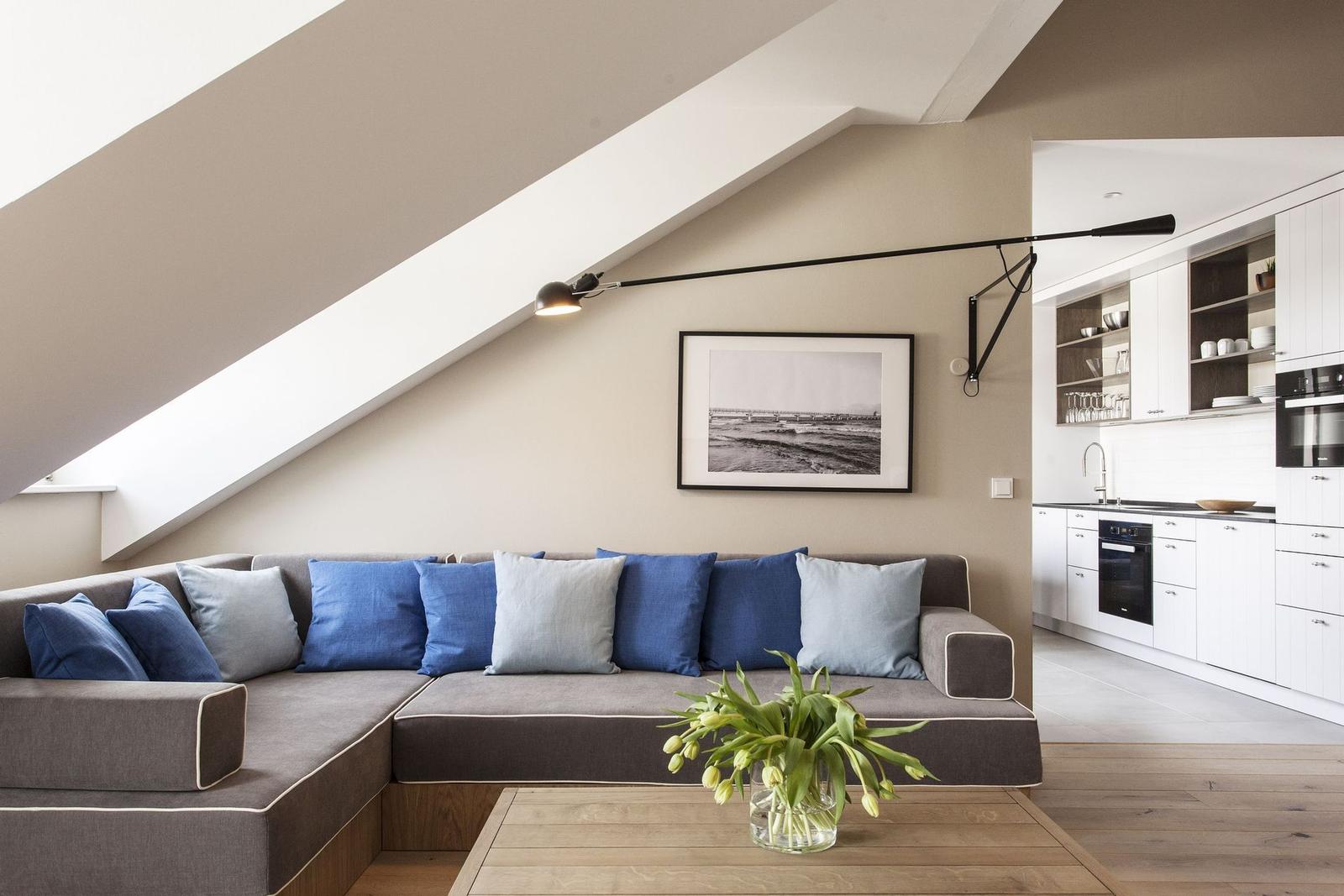 Ein Wohnbereich mit Sofa und Küchenbereich im Hintergrund.