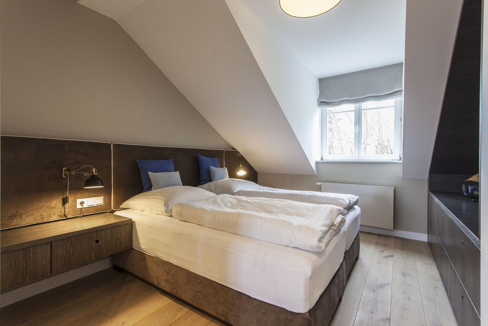 Doppelbett unter Dachschrägen mit Fenster und Nachttisch