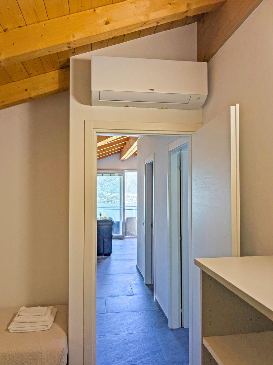 Raum mit Holzdecke, Klimaanlage und Blick auf Balkon.