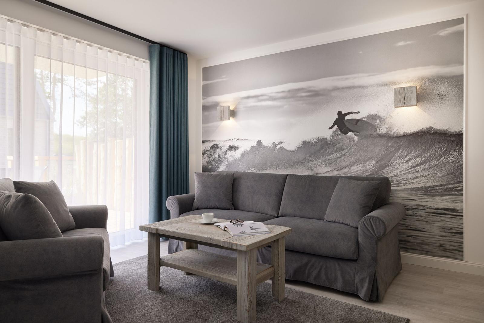 Wohnzimmer mit Sofa, Couchtisch und Wandbild von Surfer.