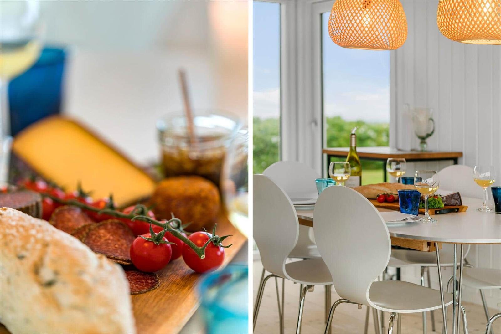 Tisch mit Speisen und Wein, Fensterblick auf Grün, hängende Lampen