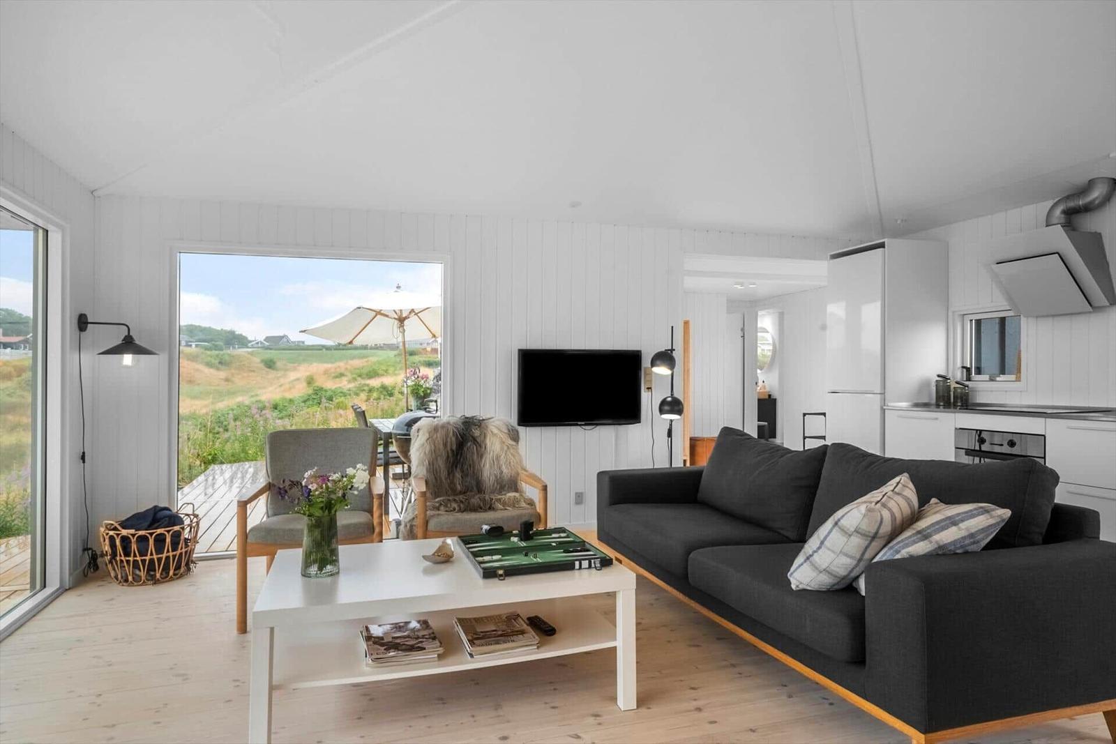 Wohnzimmer mit Sofa, Couchtisch und Blick auf Terrasse