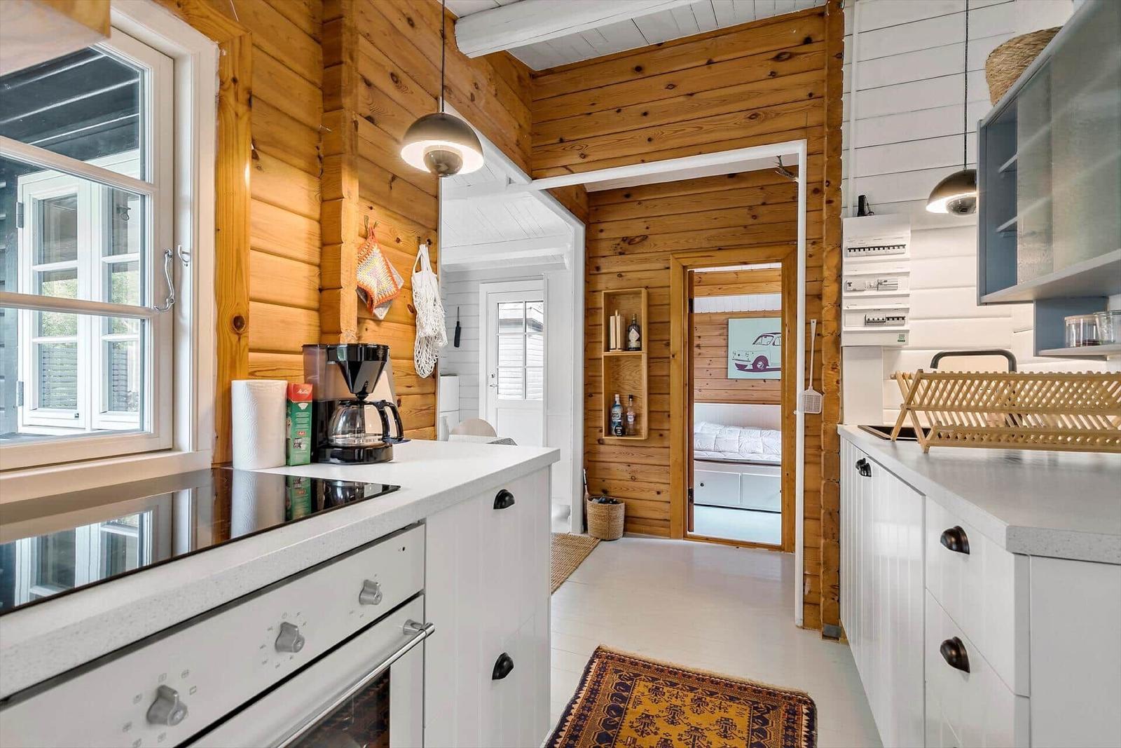 Kitchen with wooden wall and view into bedroom