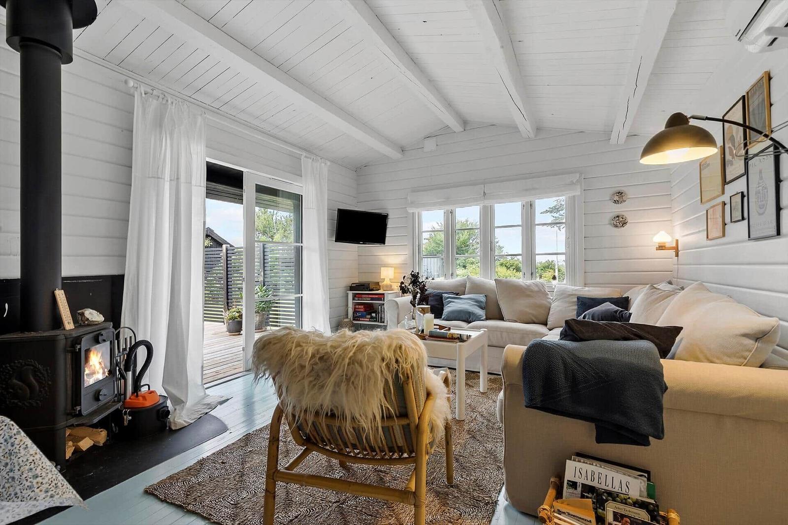 Living room with fireplace, sofa, and windows to terrace.