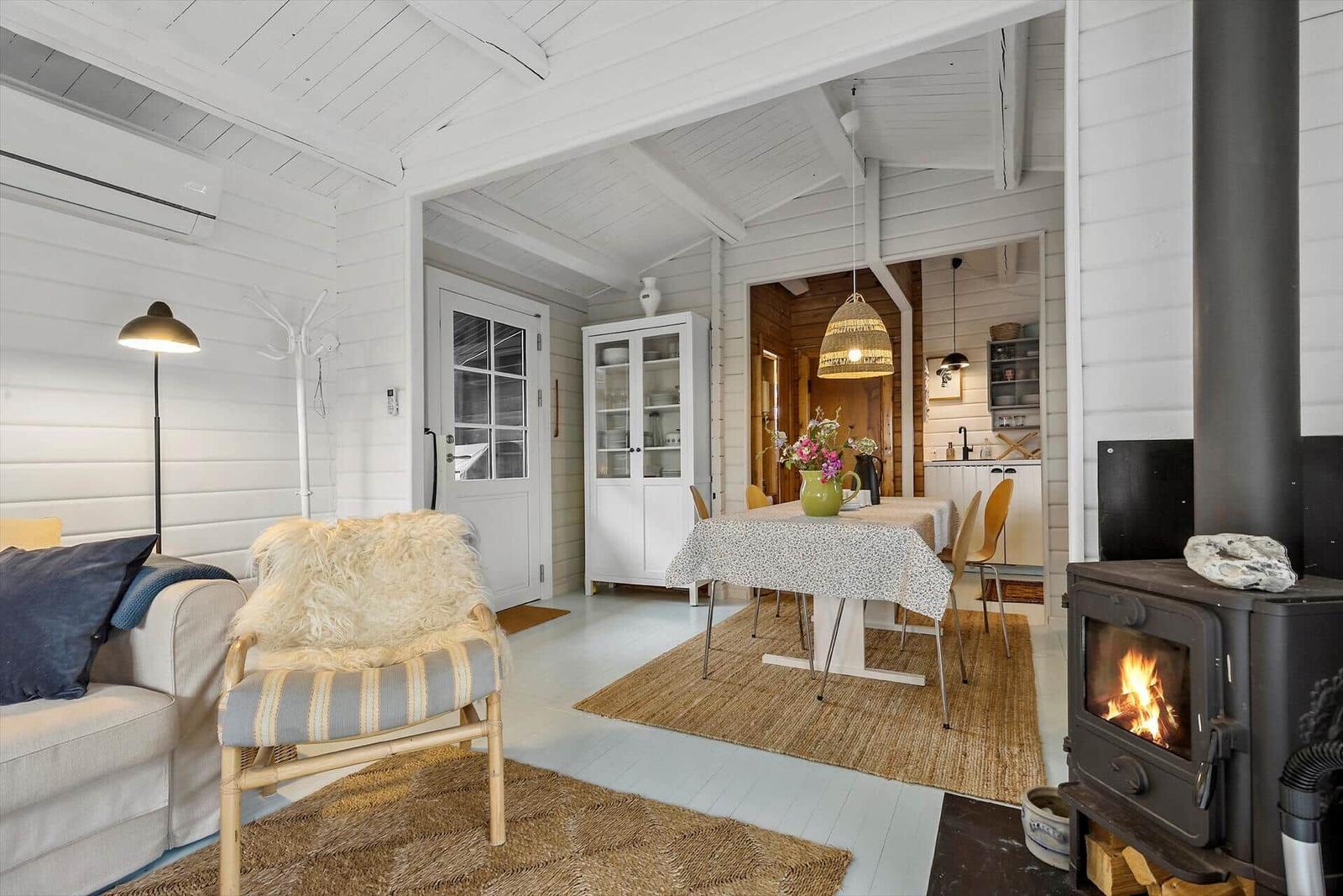 Living and dining area with fireplace, table, chairs, and cabinet.