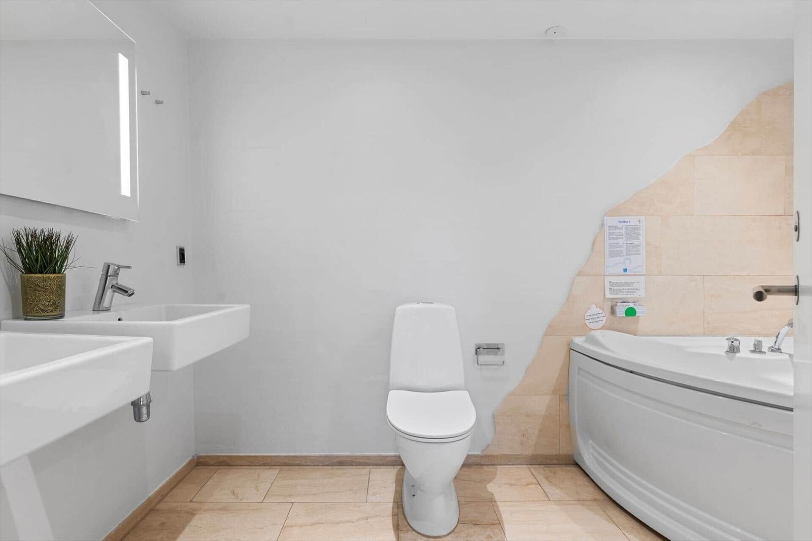 Badezimmer mit Toilette, Badewanne und Waschbecken.