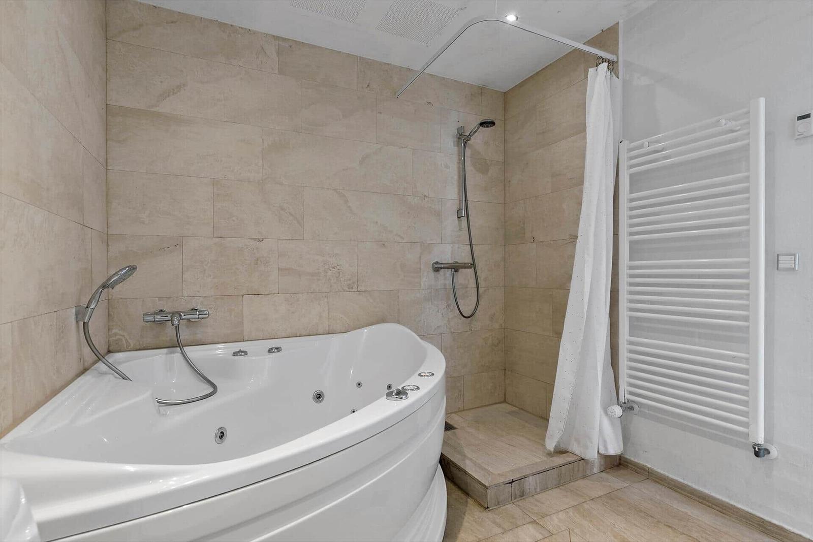 Bad mit Whirlpoolbad, Dusche und Heizkörper