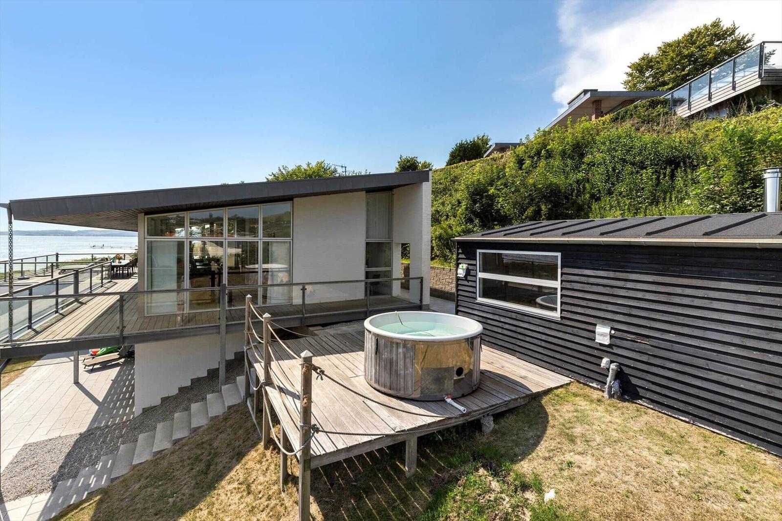 Moderne Villa mit Whirlpool und Meerblick auf Terrasse.