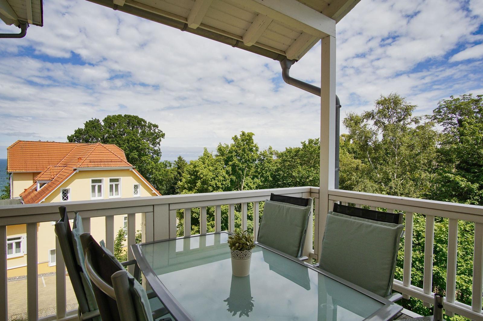 Terrasse mit Tisch und Stühlen, Blick auf Haus und Bäume
