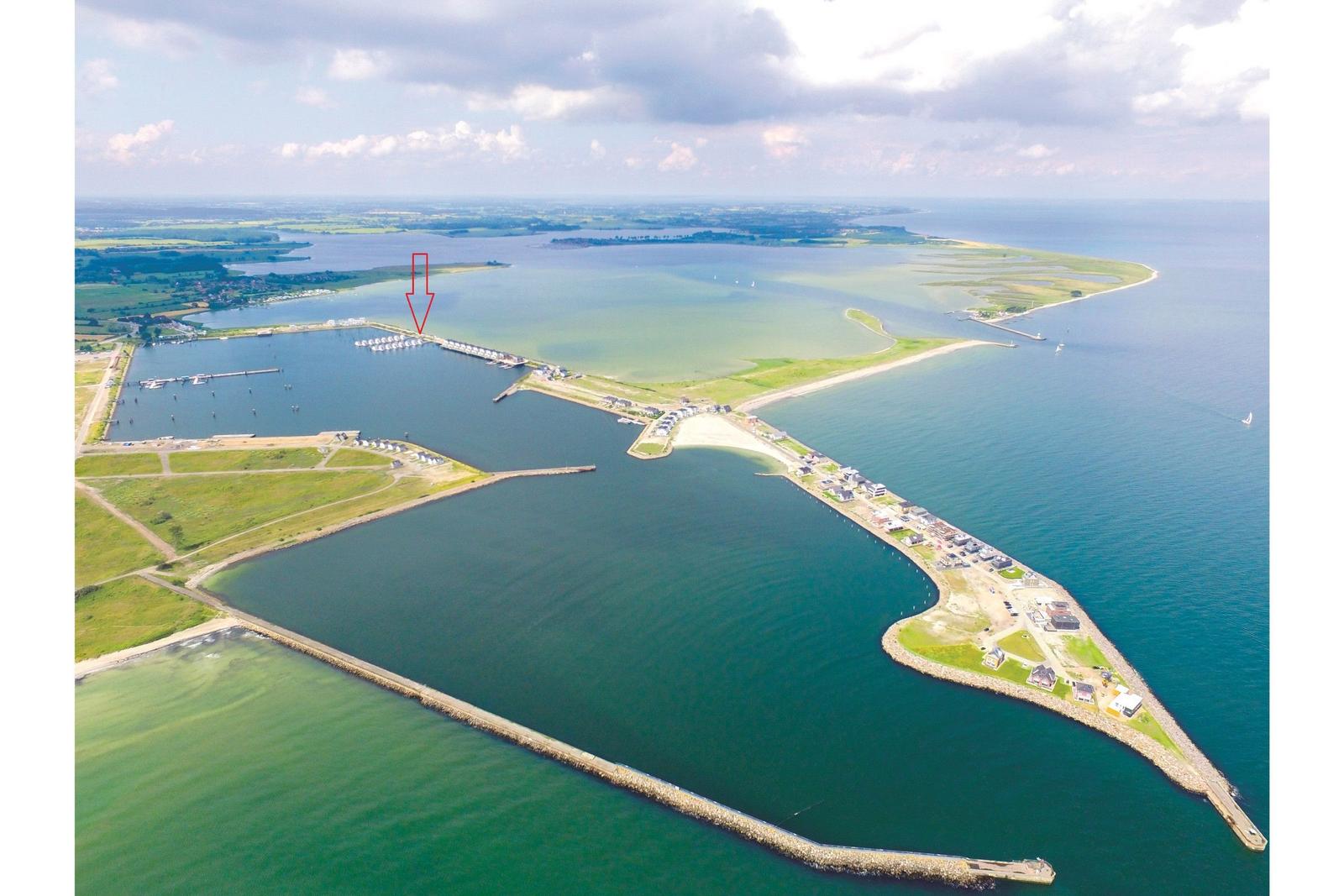 Aerial view of a coastal area with marina, docks, and surrounding waterways.