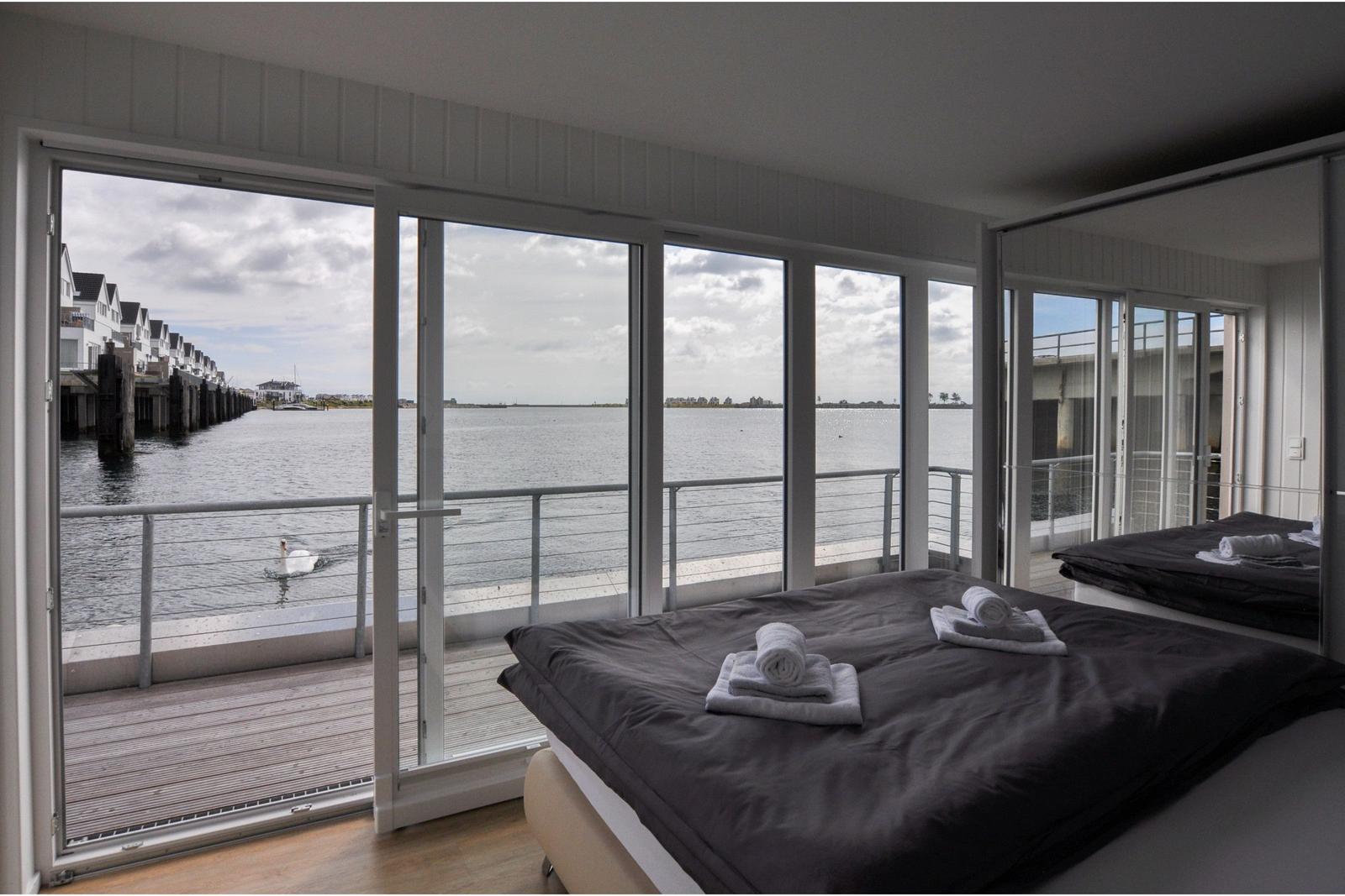 Schlafzimmer mit Blick auf Wasser und Schwäne.