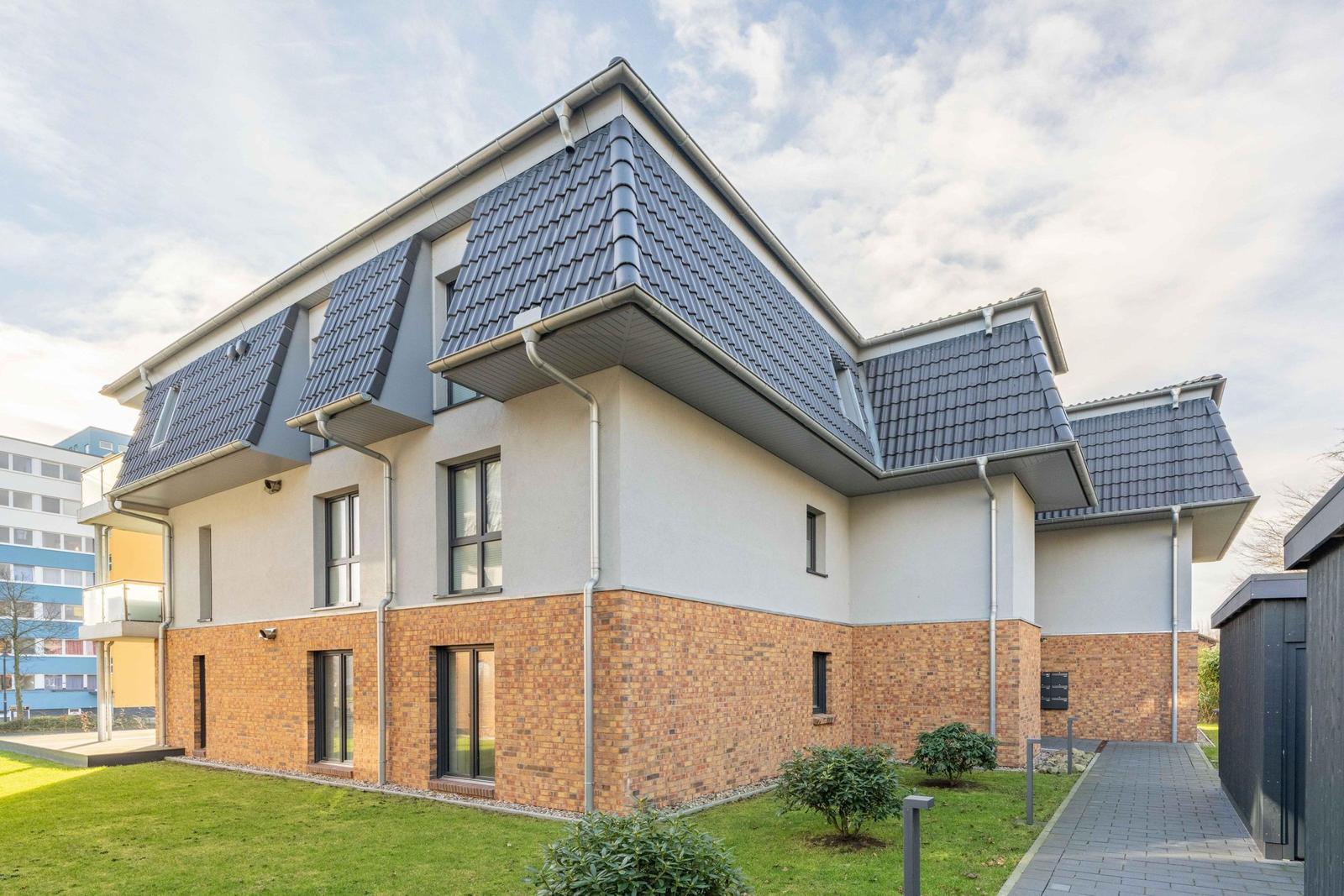 Moderne zweistöckige Villa mit Ziegelfassade und Dachgauben.