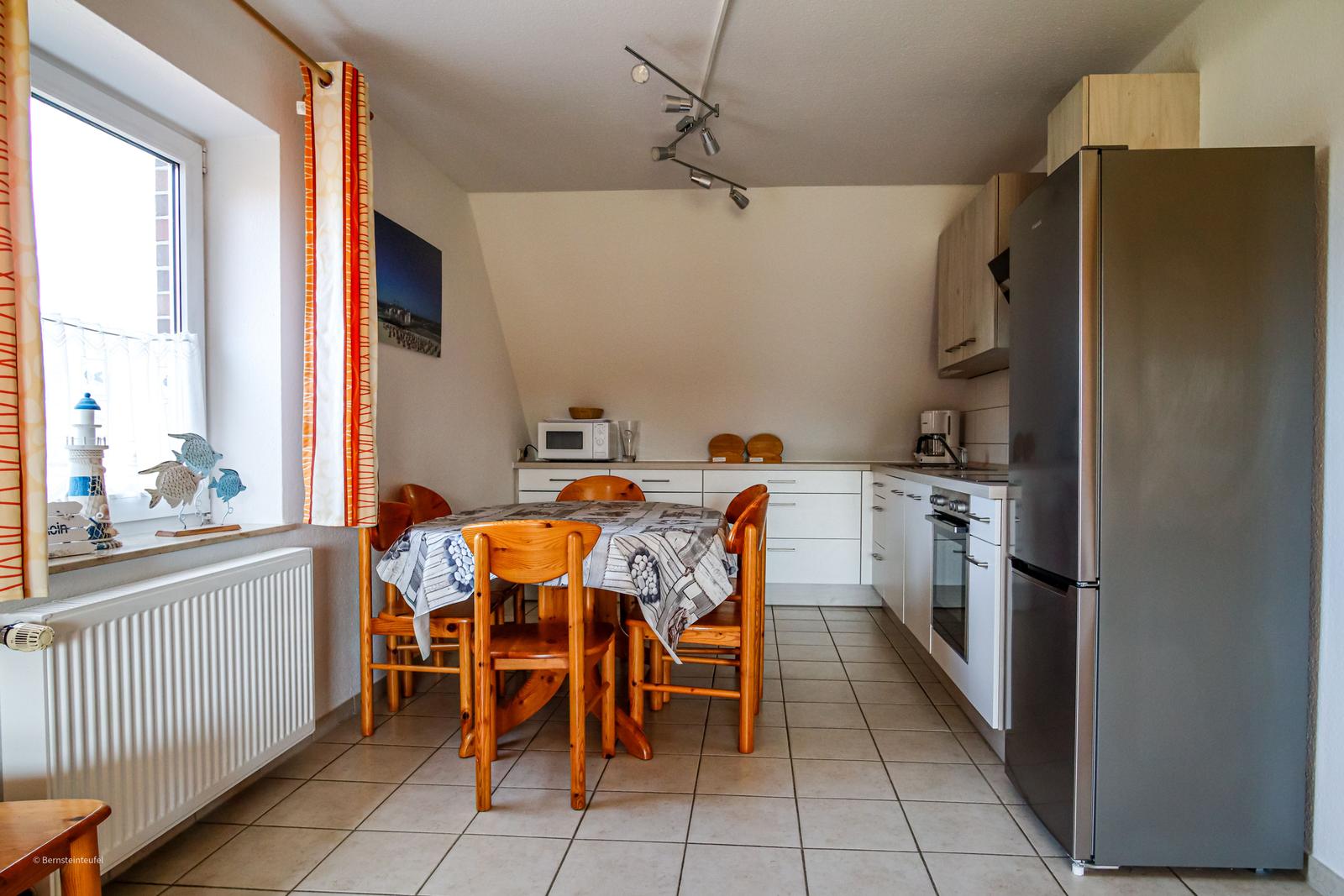 Moderne Küche mit großer Gefrier-Kühlschrankkombination,
Backofen , Mikrowelle, Kaffemaschine und Wasserkocher.
großer Esstisch.