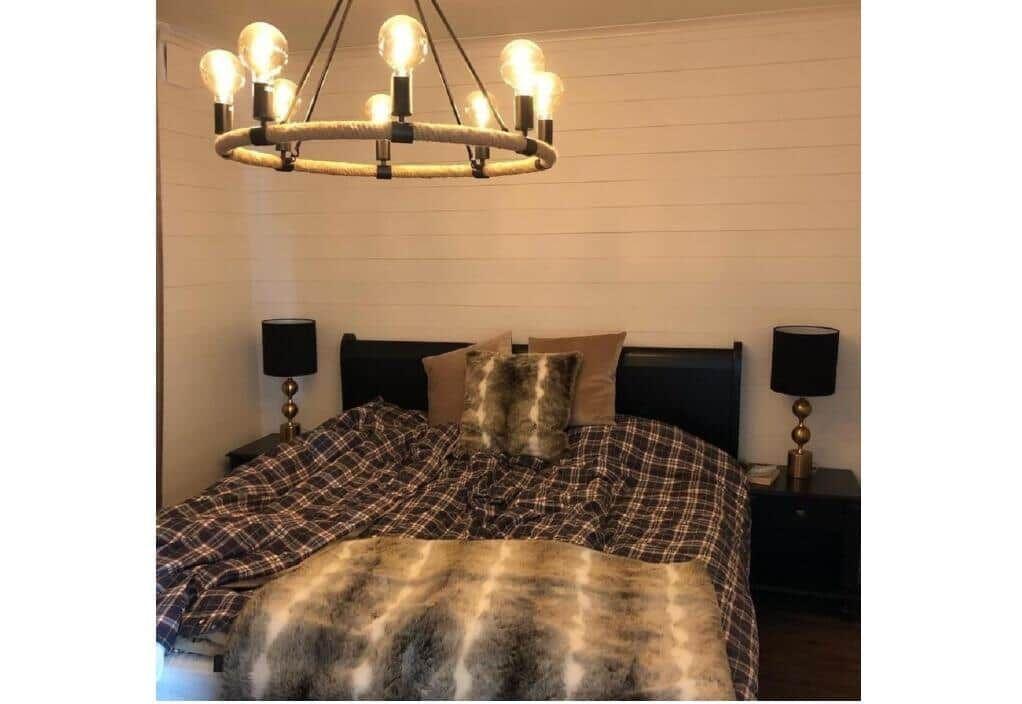 Schlafzimmer mit Bett, Nachttischen und Kronleuchter.