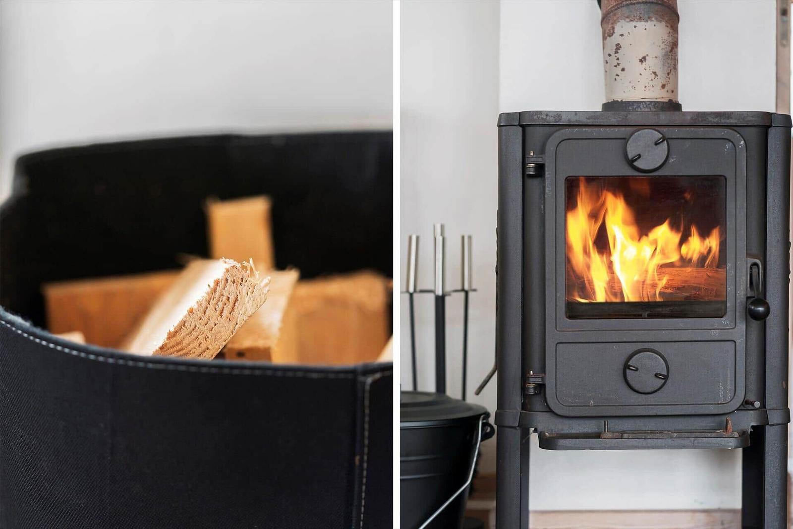 Holzstapel und brennender Kaminofen in einem Raum.