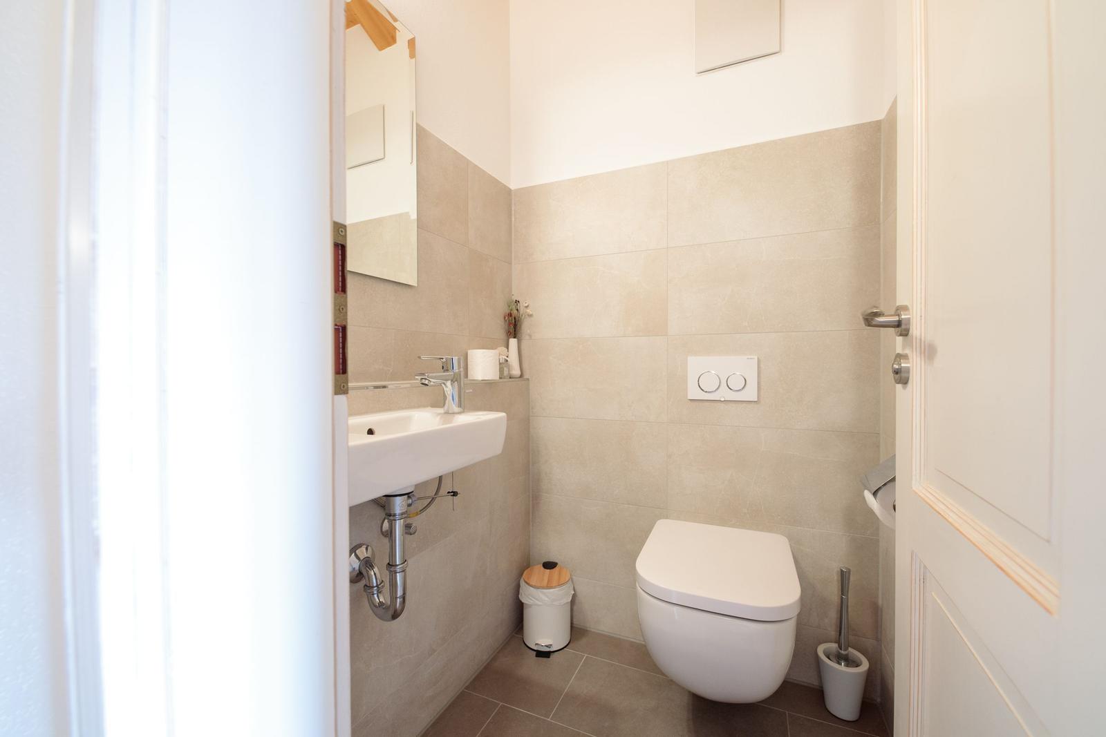 Badezimmer mit Waschbecken, Spiegel und WC.