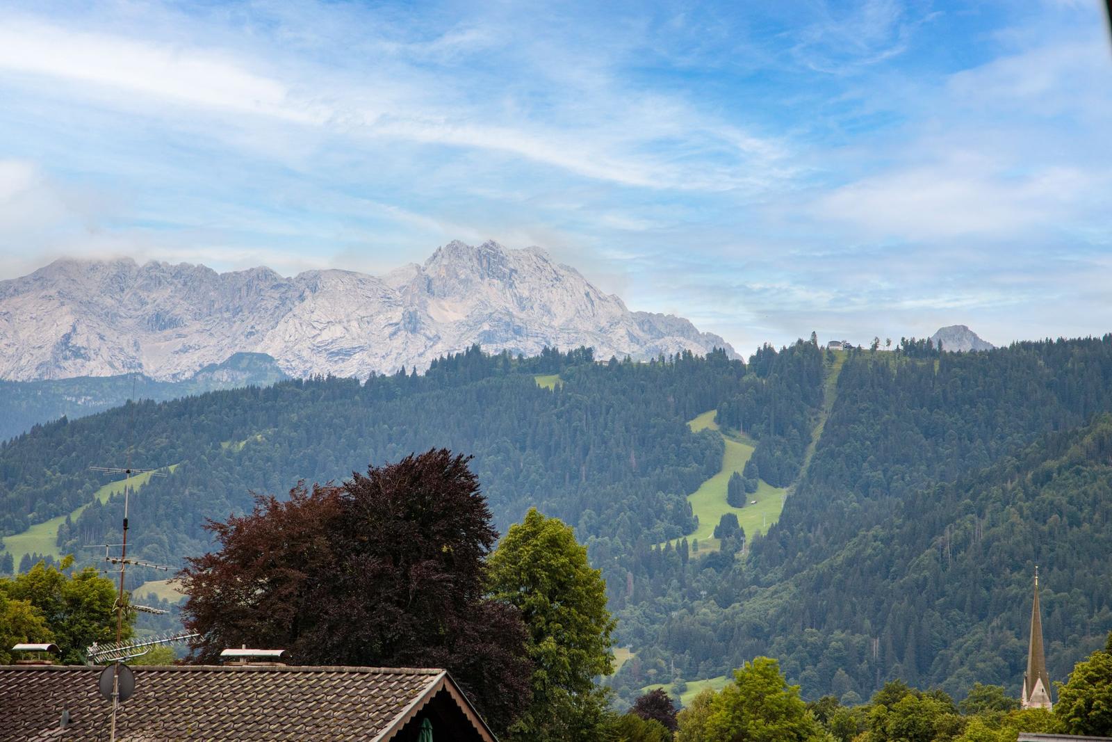Blick auf Berge, Wälder und einen Kirchturm