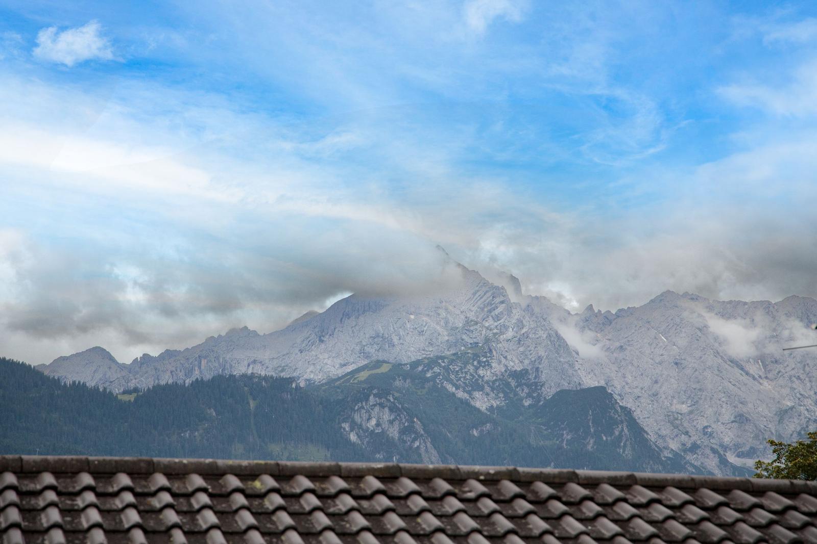 Blick auf Berge mit Wolken über einem Dach