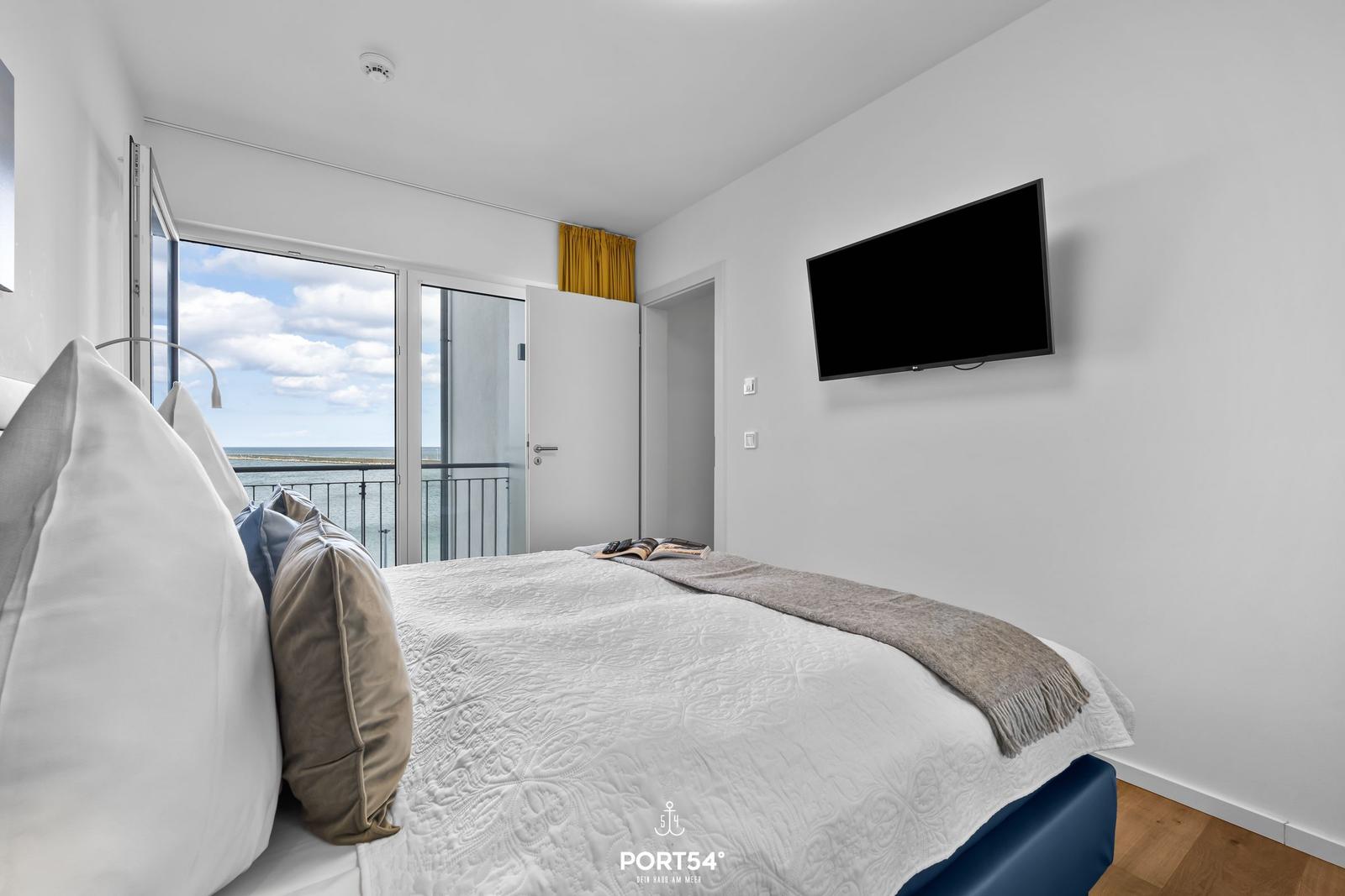 Schlafzimmer mit Blick aufs Meer und TV-Wandmontage.