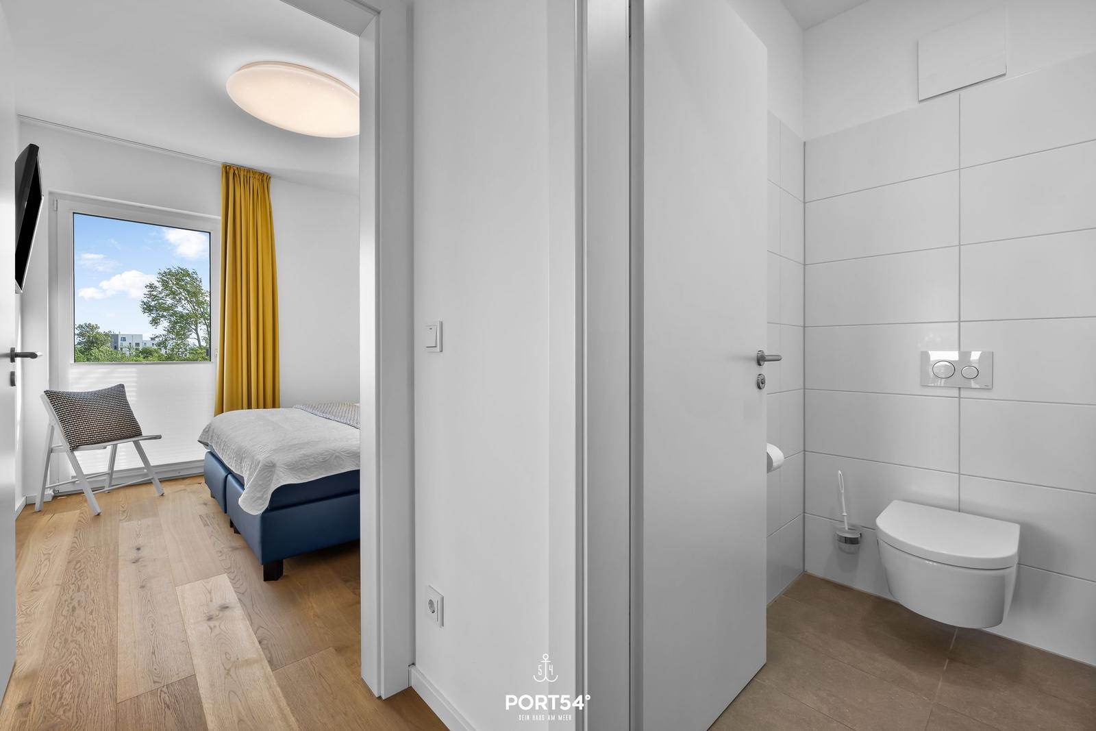 Schlafzimmer mit Blick auf Außenbereich und Badezimmer mit Toilette