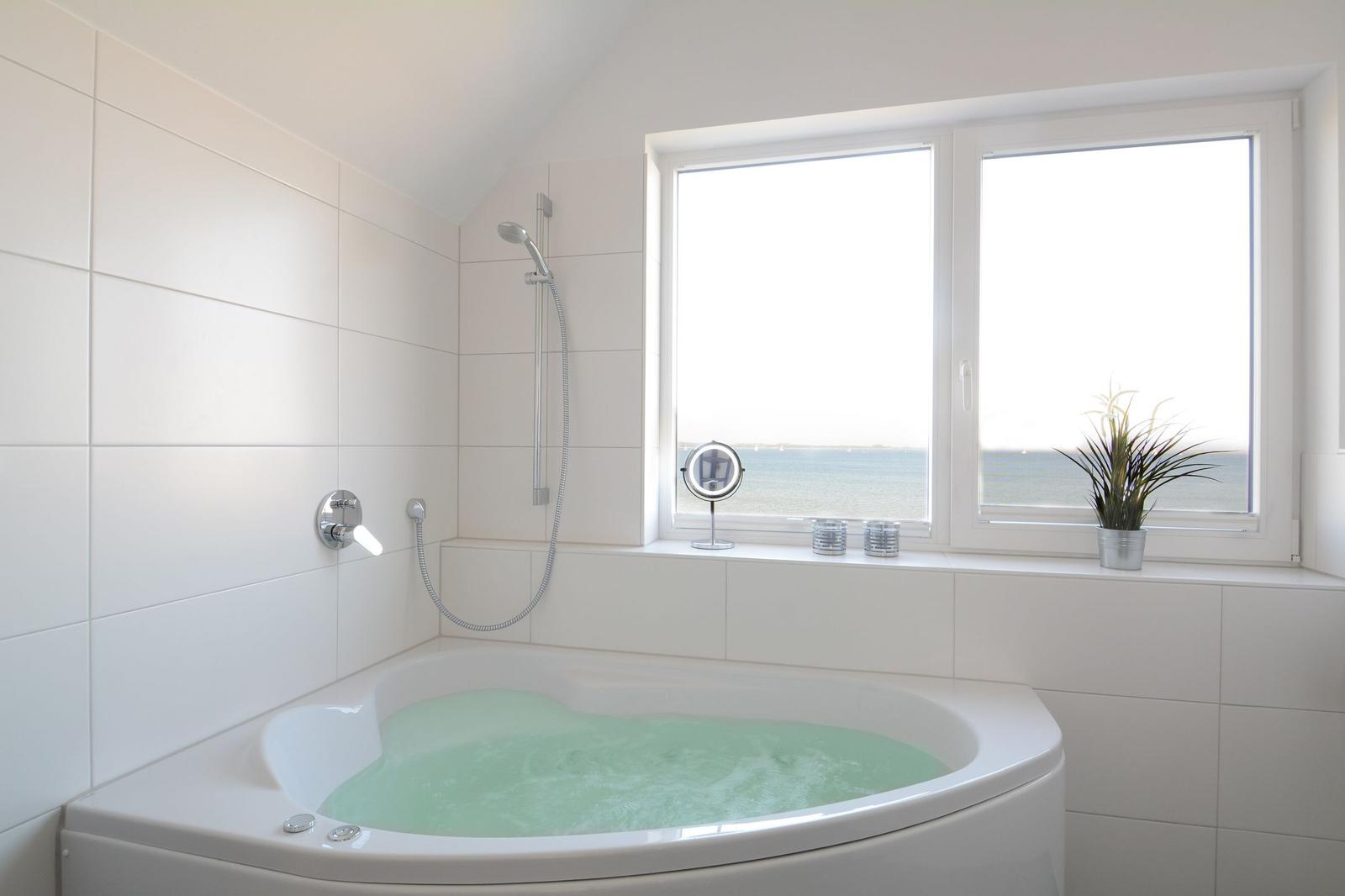 Bad mit Whirlpool, Dusche und Fensterblick aufs Meer.