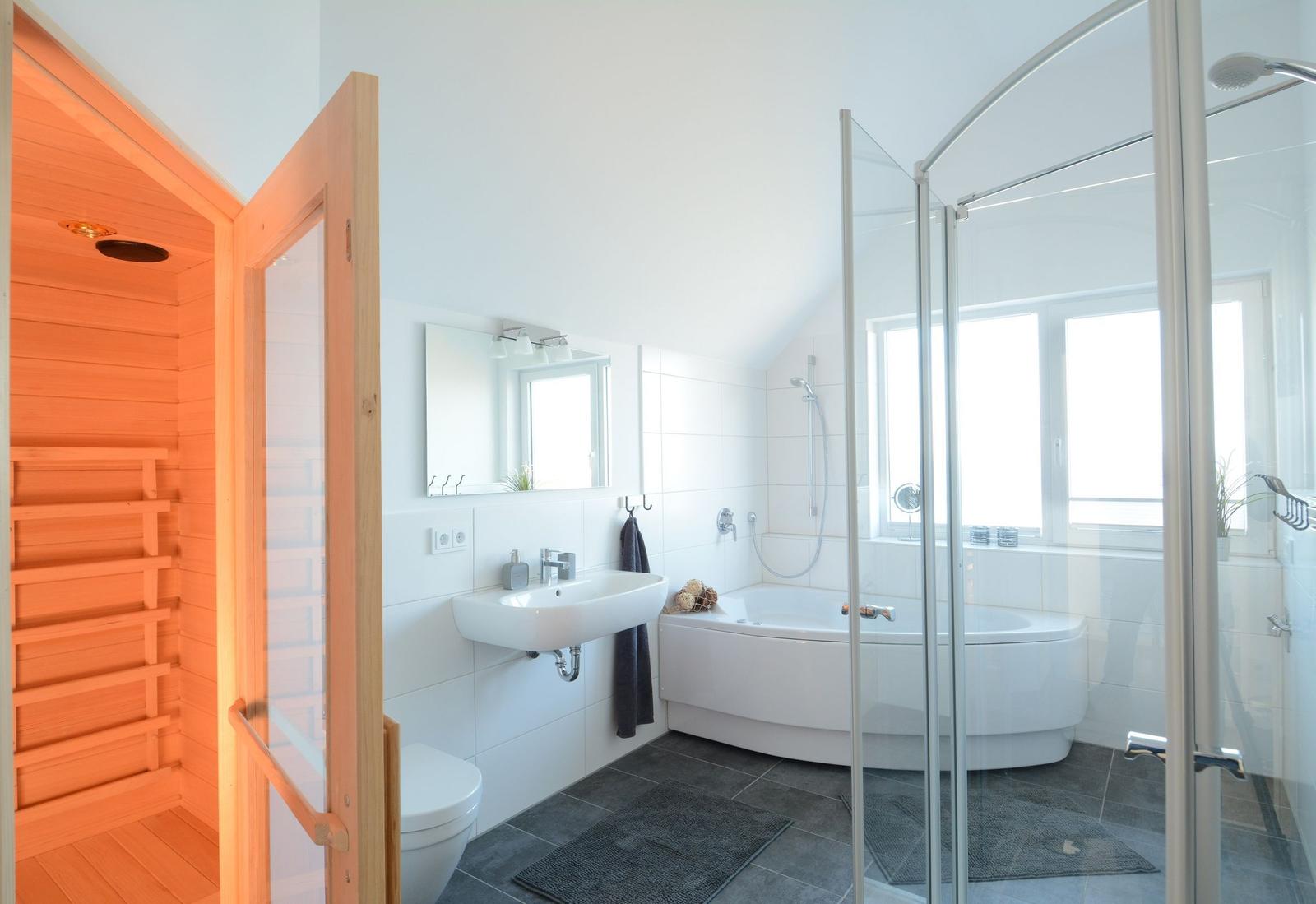 Badezimmer mit Sauna, Badewanne und Dusche.